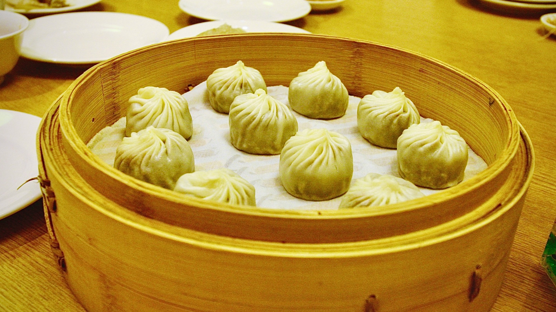 Steamed dumplings served in a bamboo steamer basket.