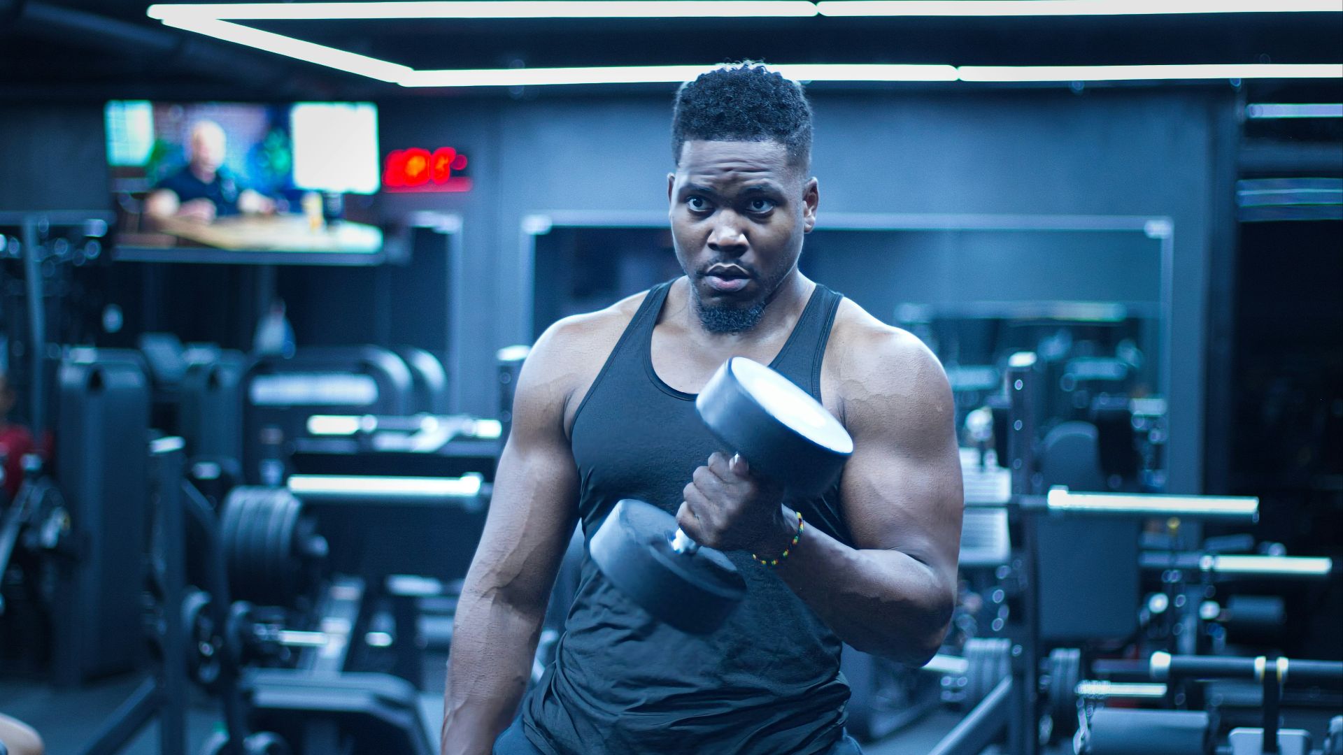 Man lifts a dumbbell in a gym.