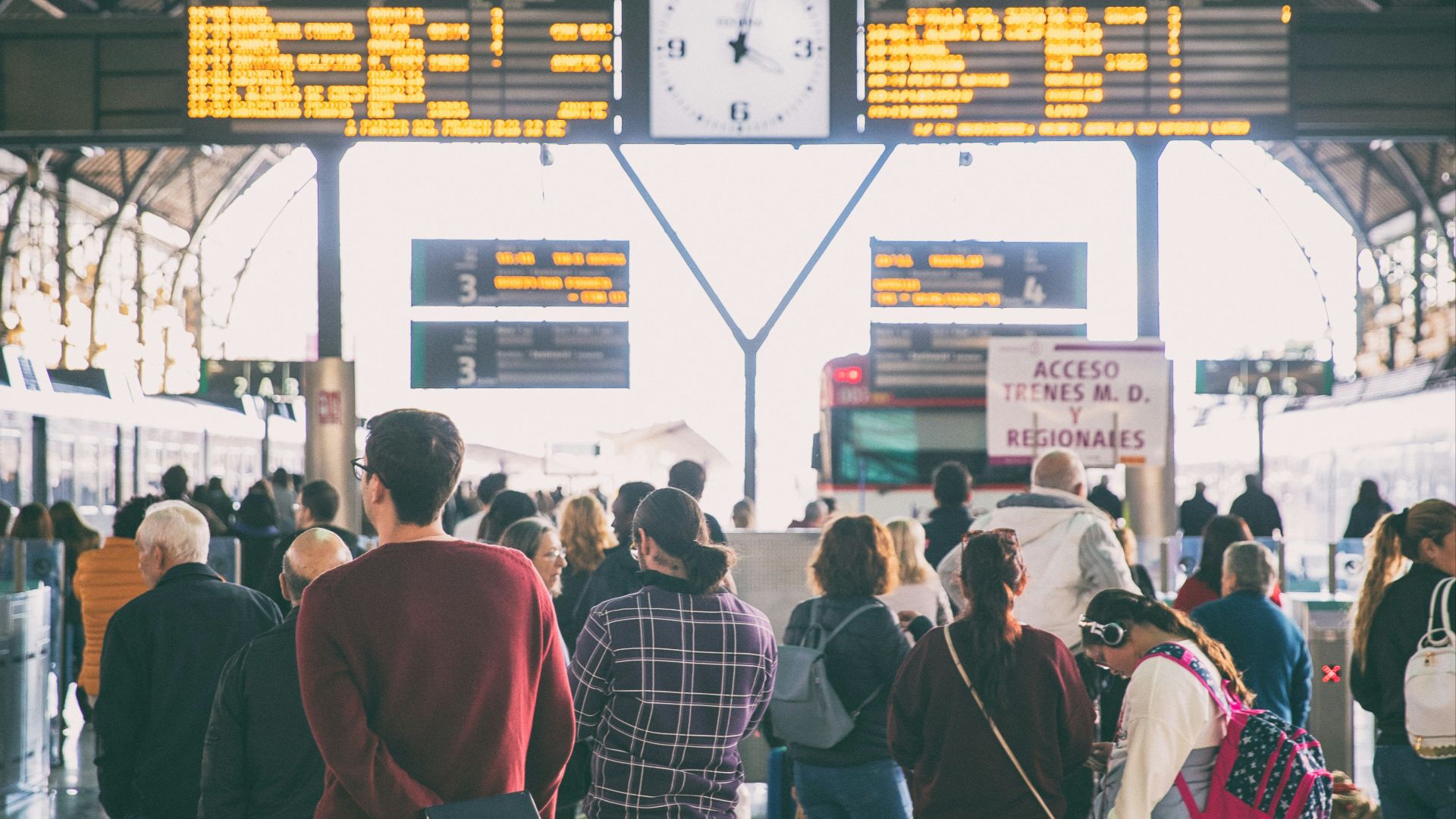 a group of people walking through a train station