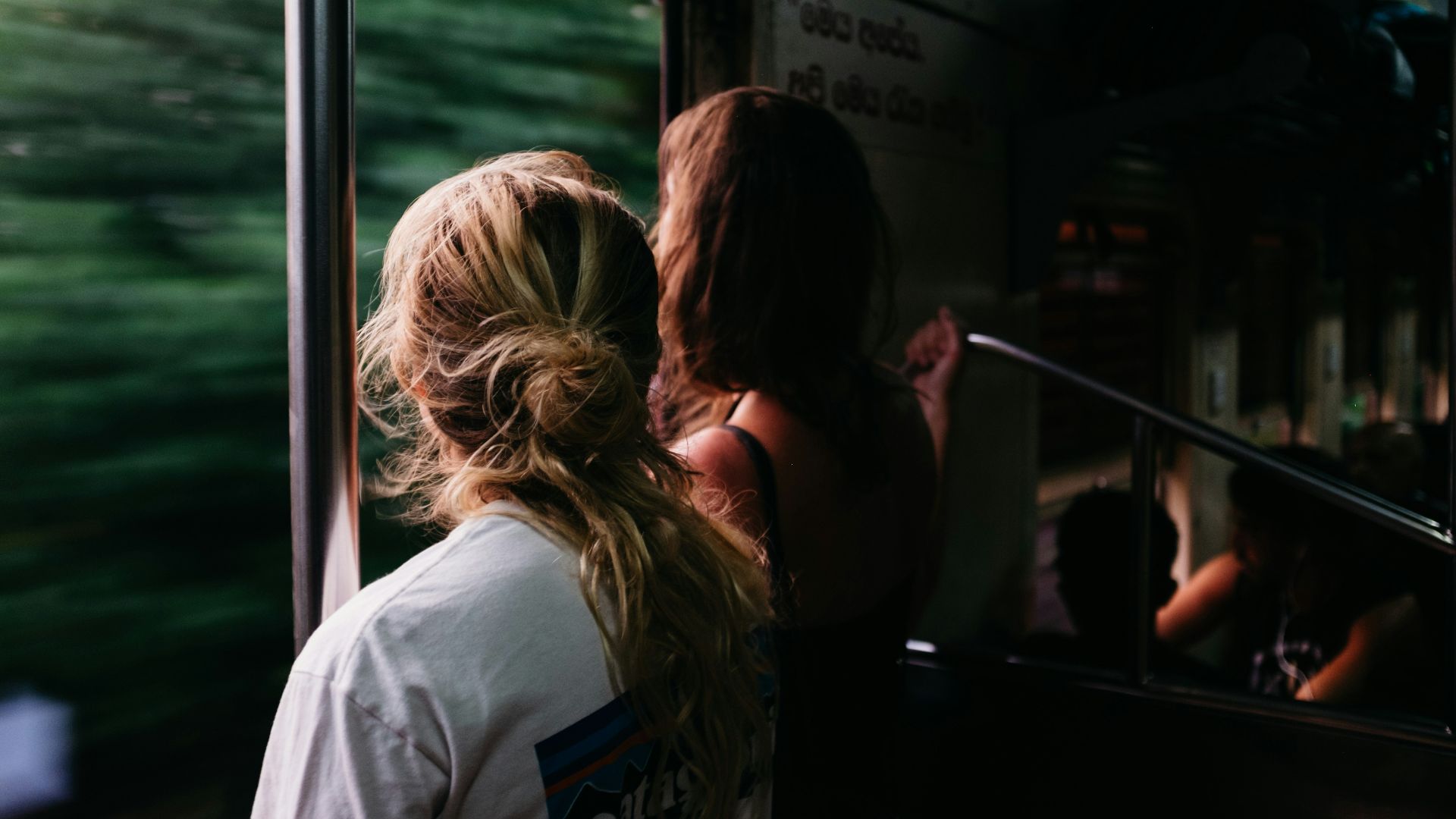 two person standing on train window