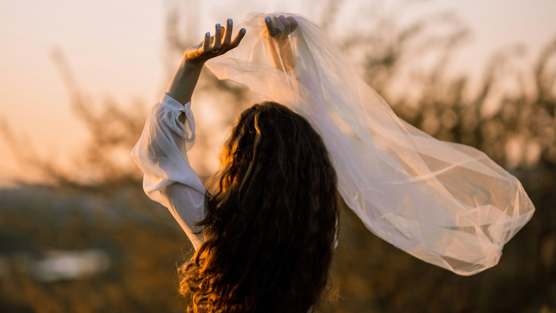 a woman wearing a white dress and a white shawl