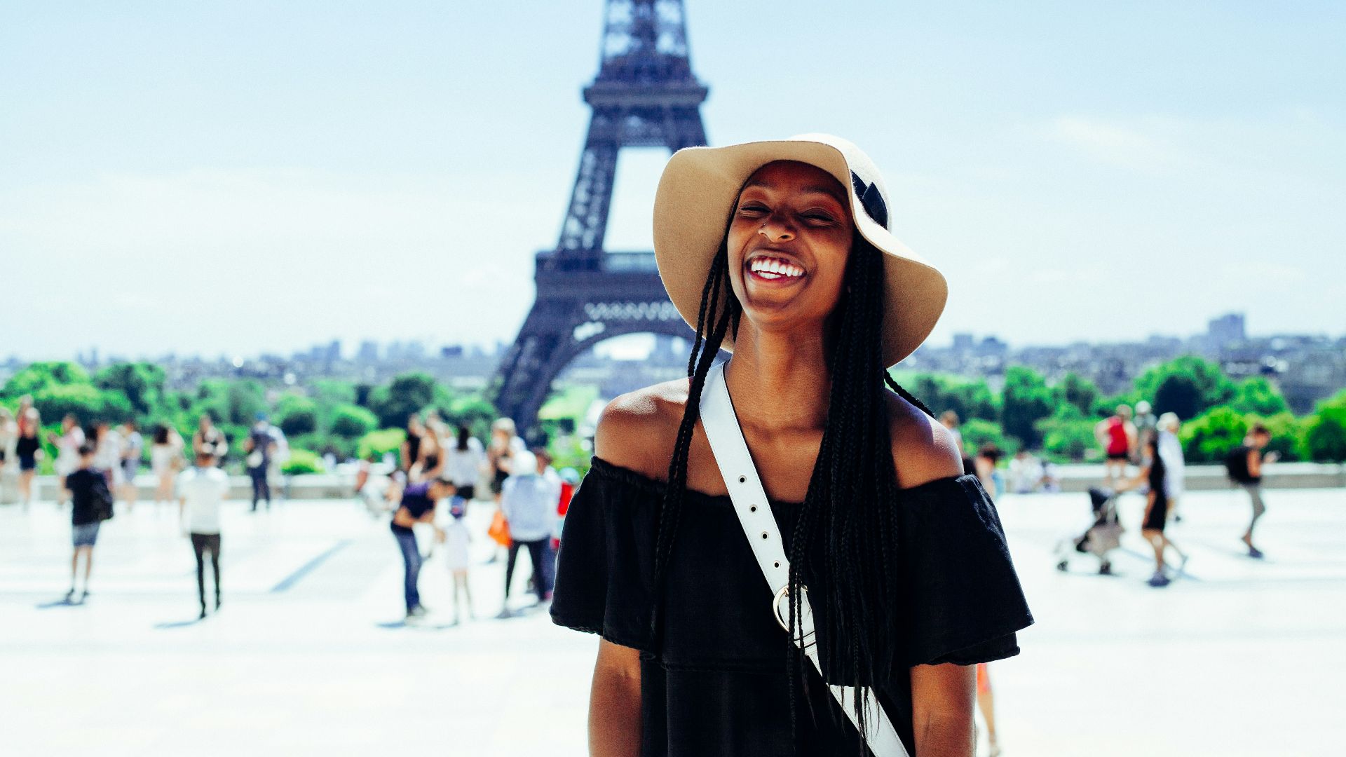 woman standing behind Eiffel Tower during daytime