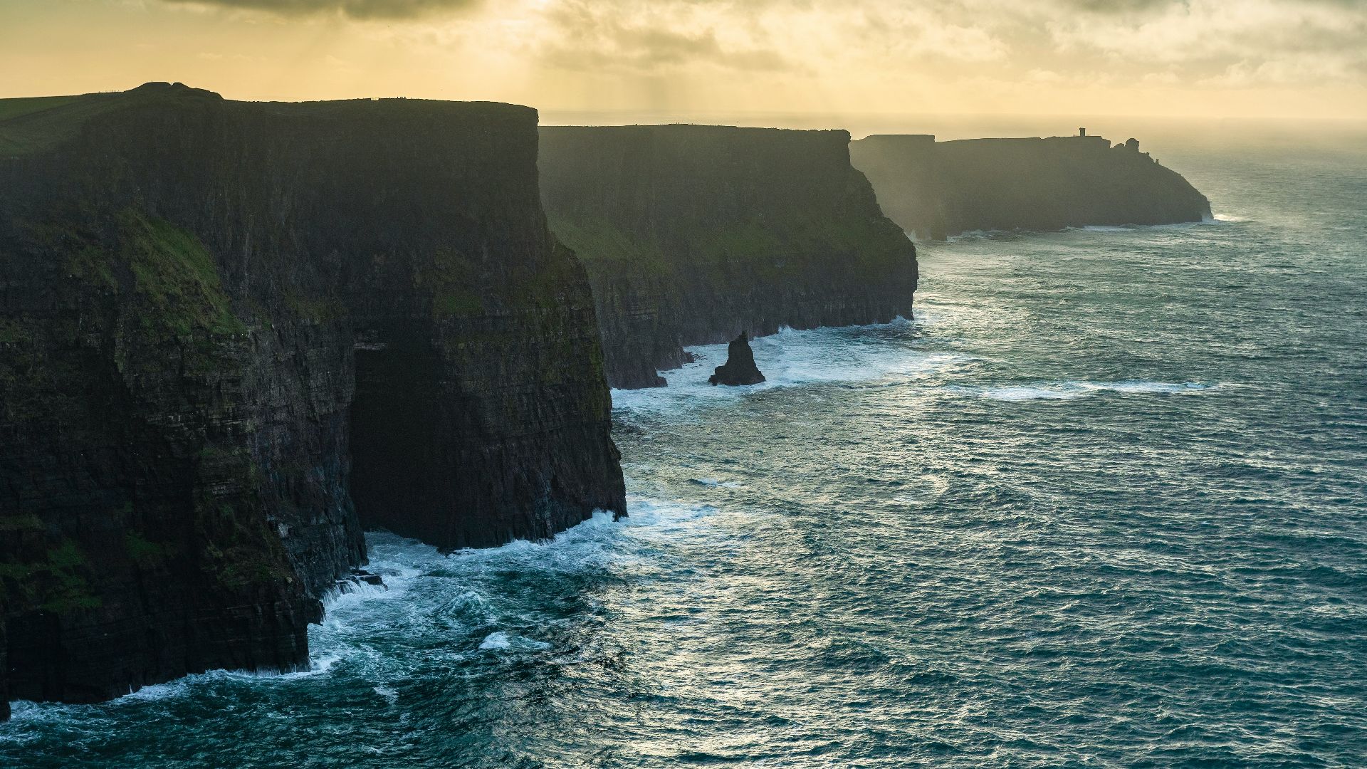 a large body of water next to a rocky cliff