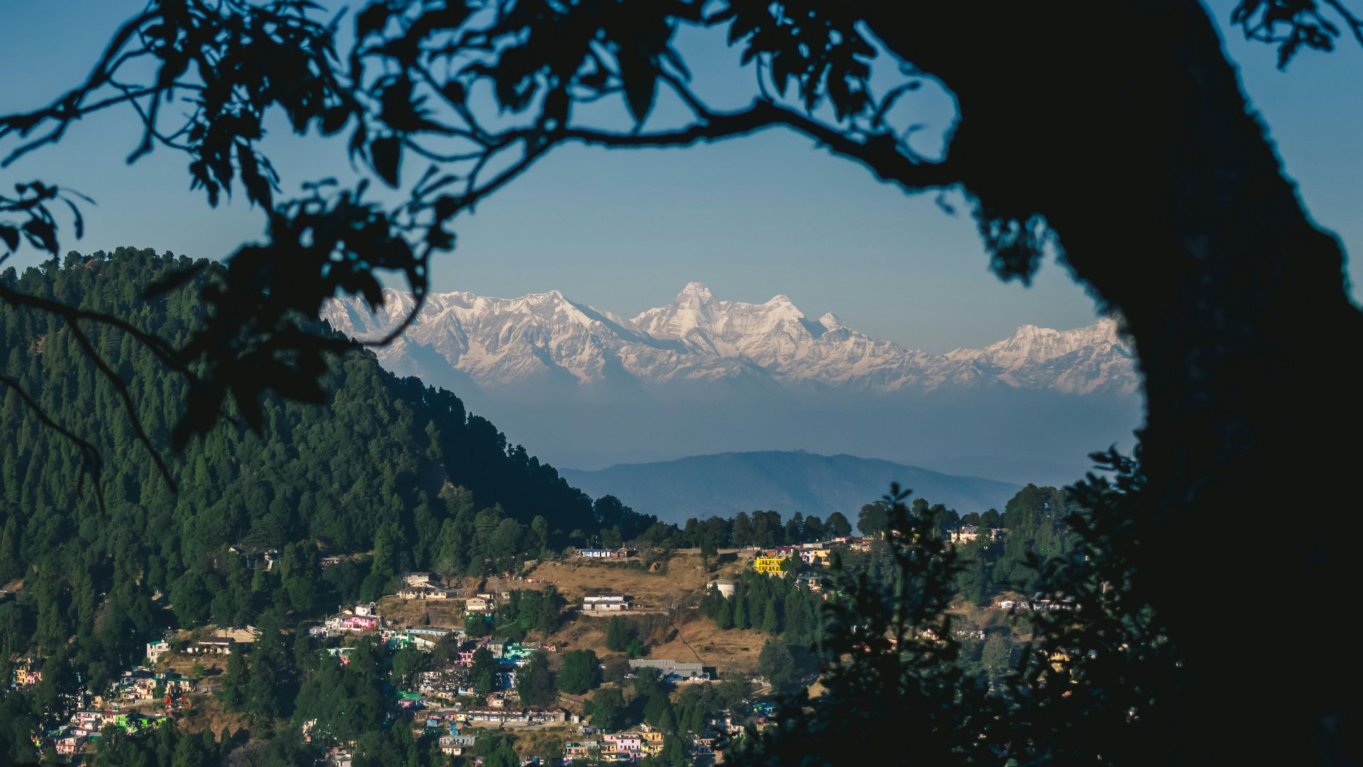 city with high rise buildings near mountain under blue sky during daytime