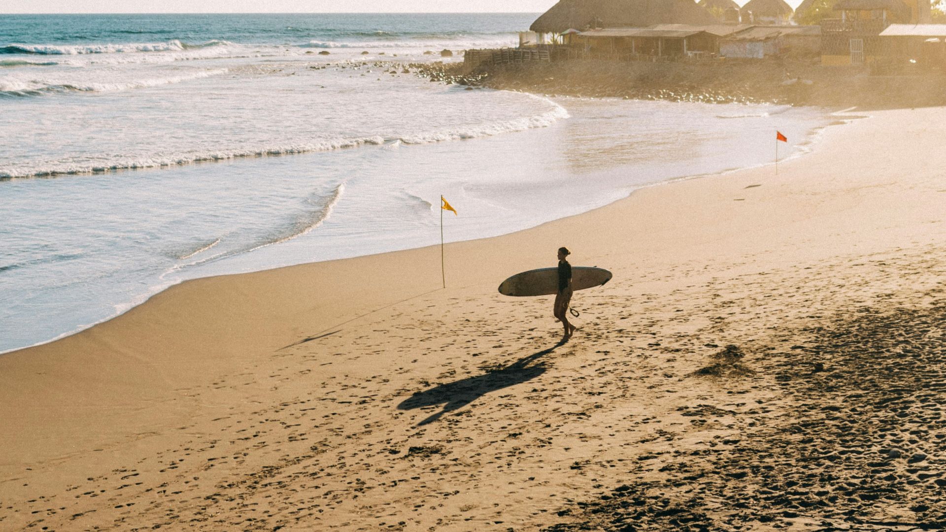 a person holding a surfboard on a beach
