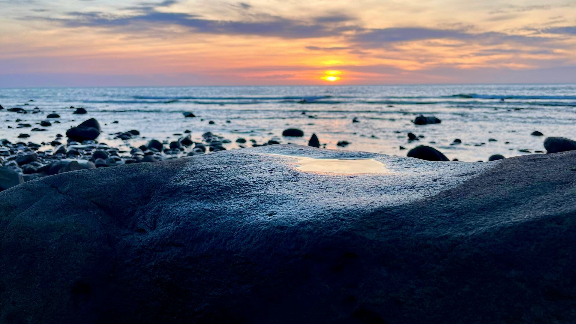 sea waves crashing on shore during sunset