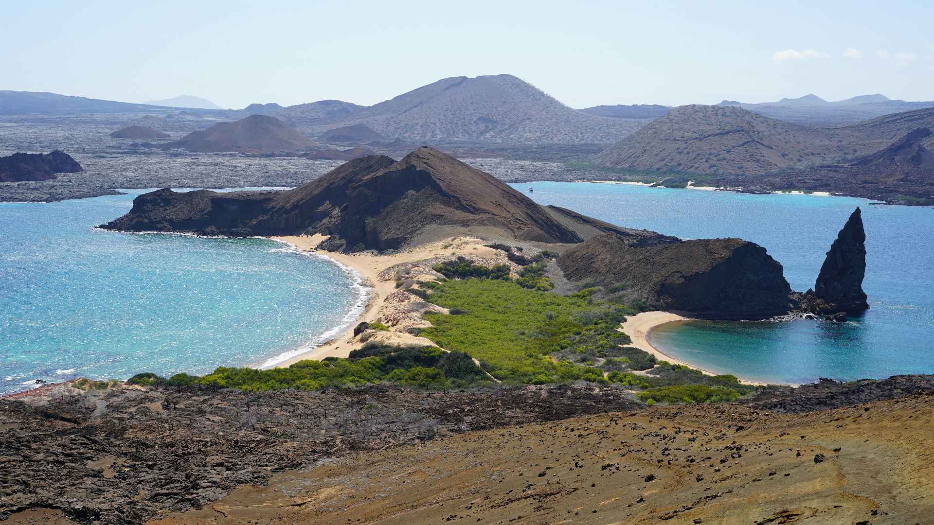 an island with a sandy beach and blue water