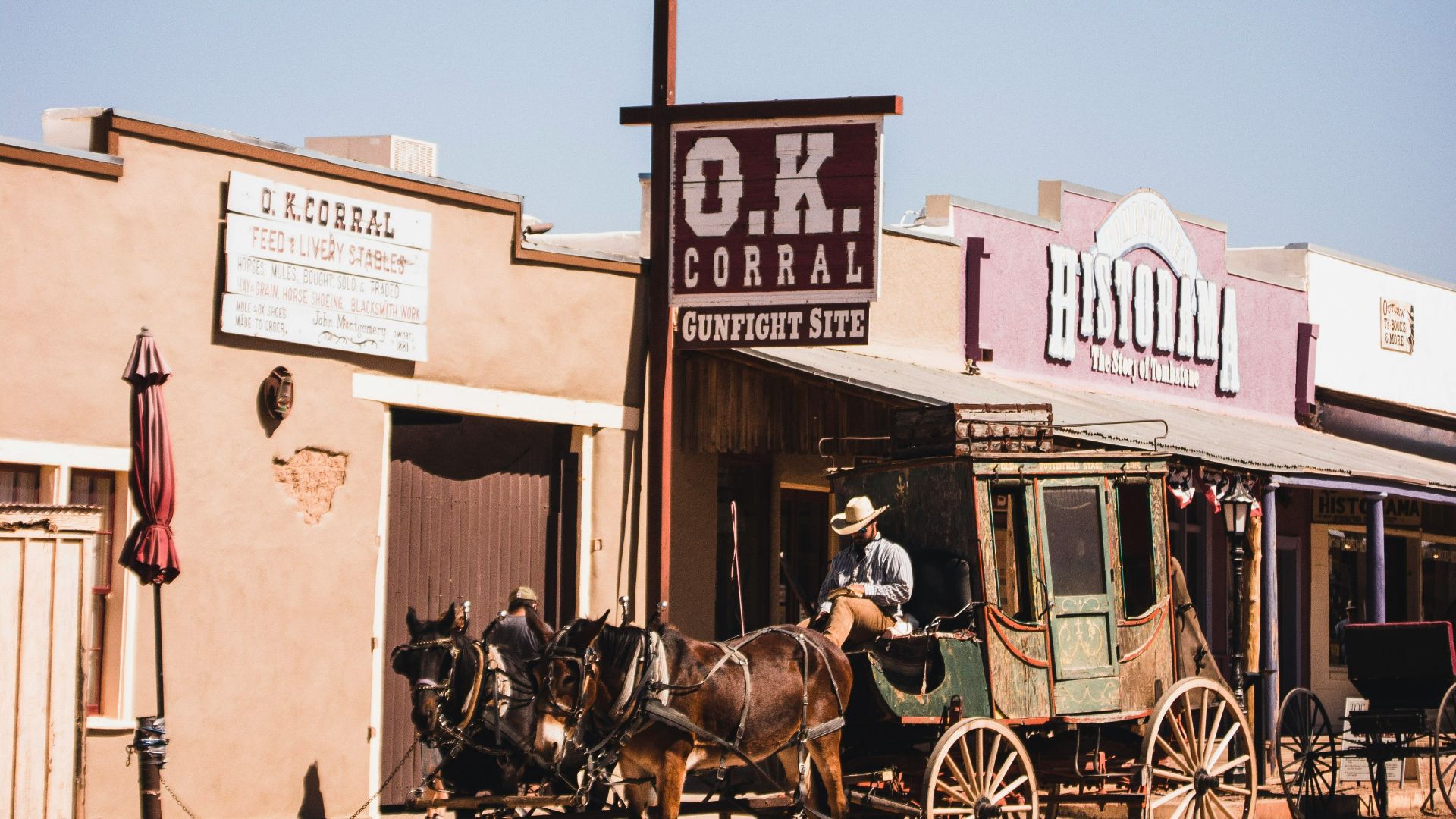 people riding horses in front of brown concrete building during daytime