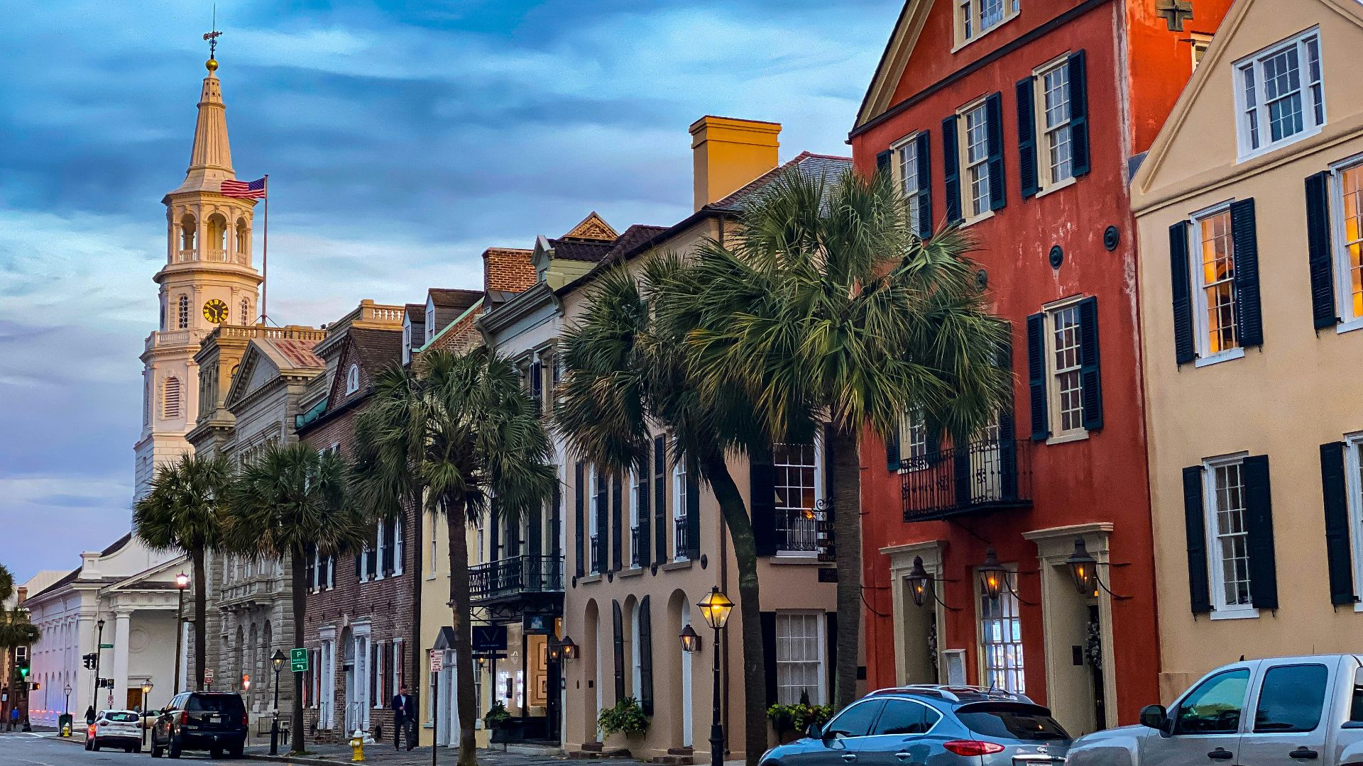 cars parked beside brown concrete building during daytime