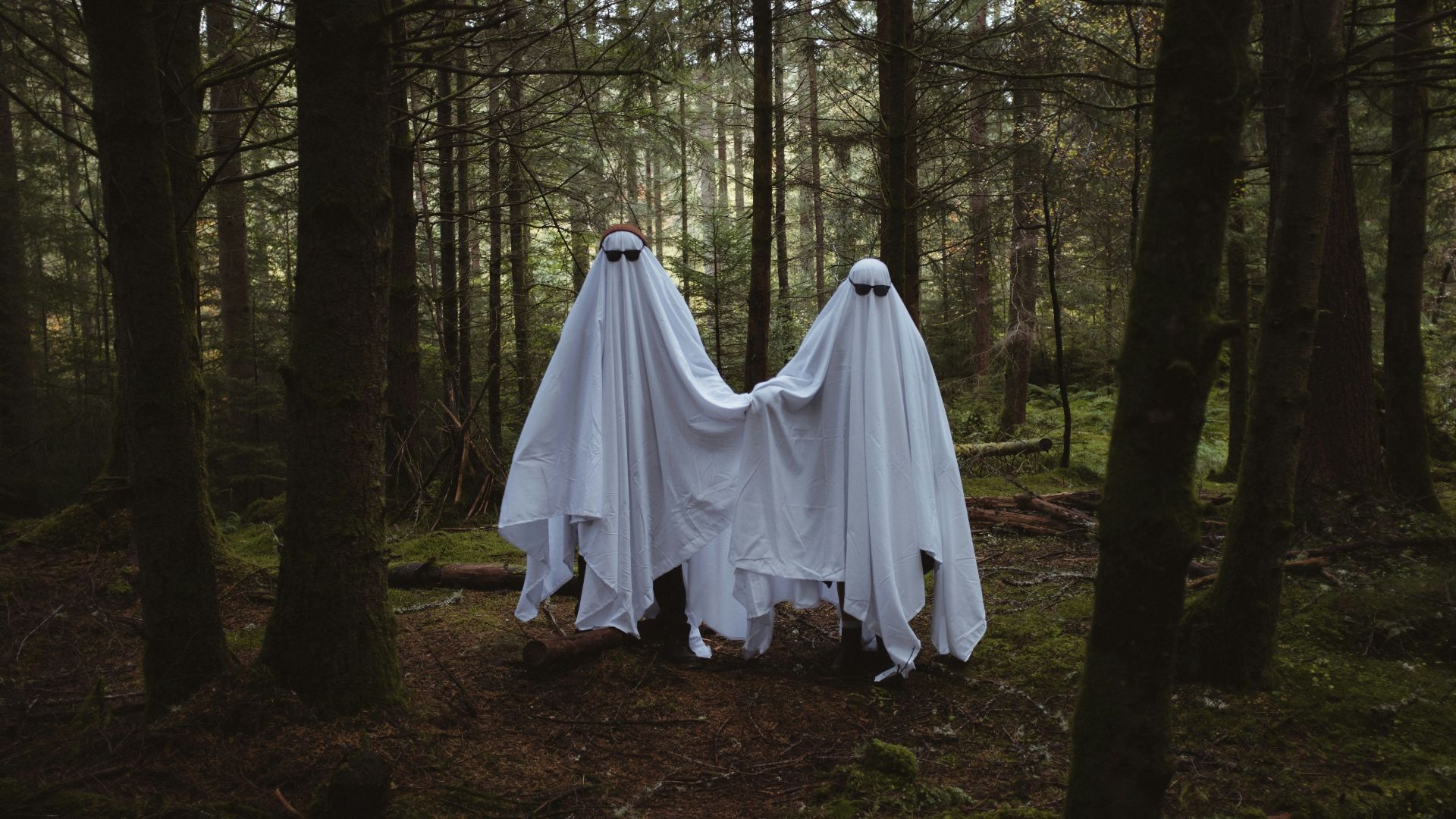 two people in white dresses in a forest