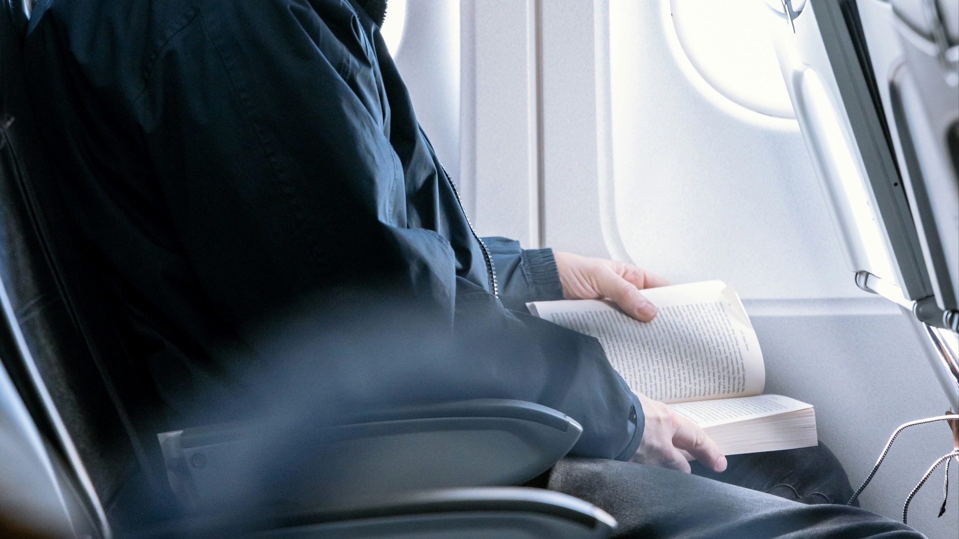 a man reading a book on an airplane
