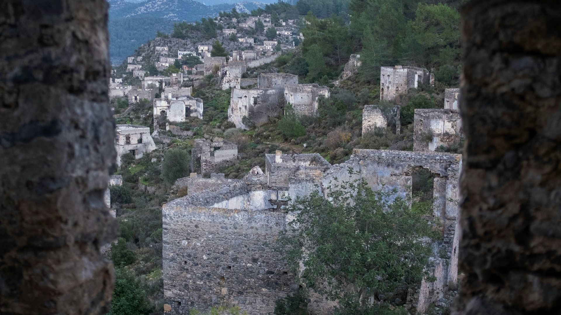 a view of a city through a hole in a stone wall