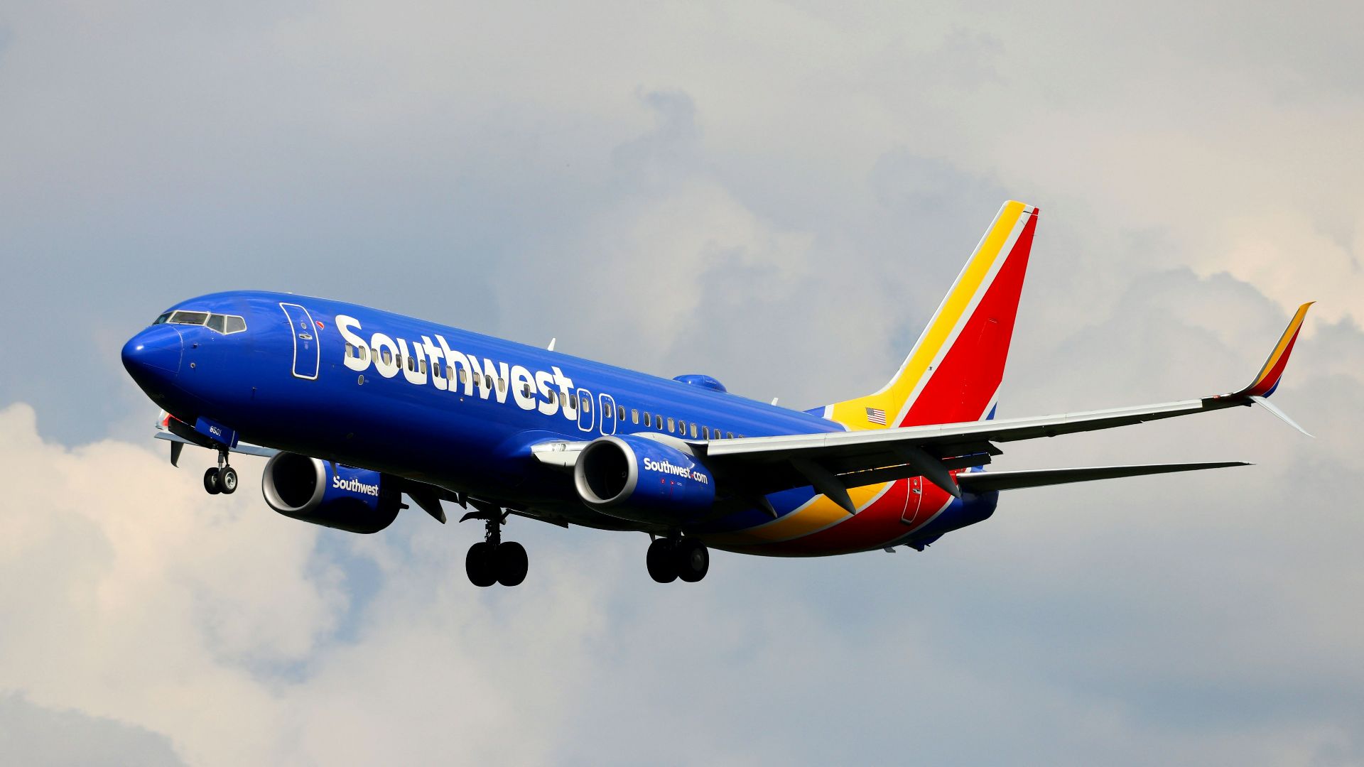 a blue and white airplane flying in the sky