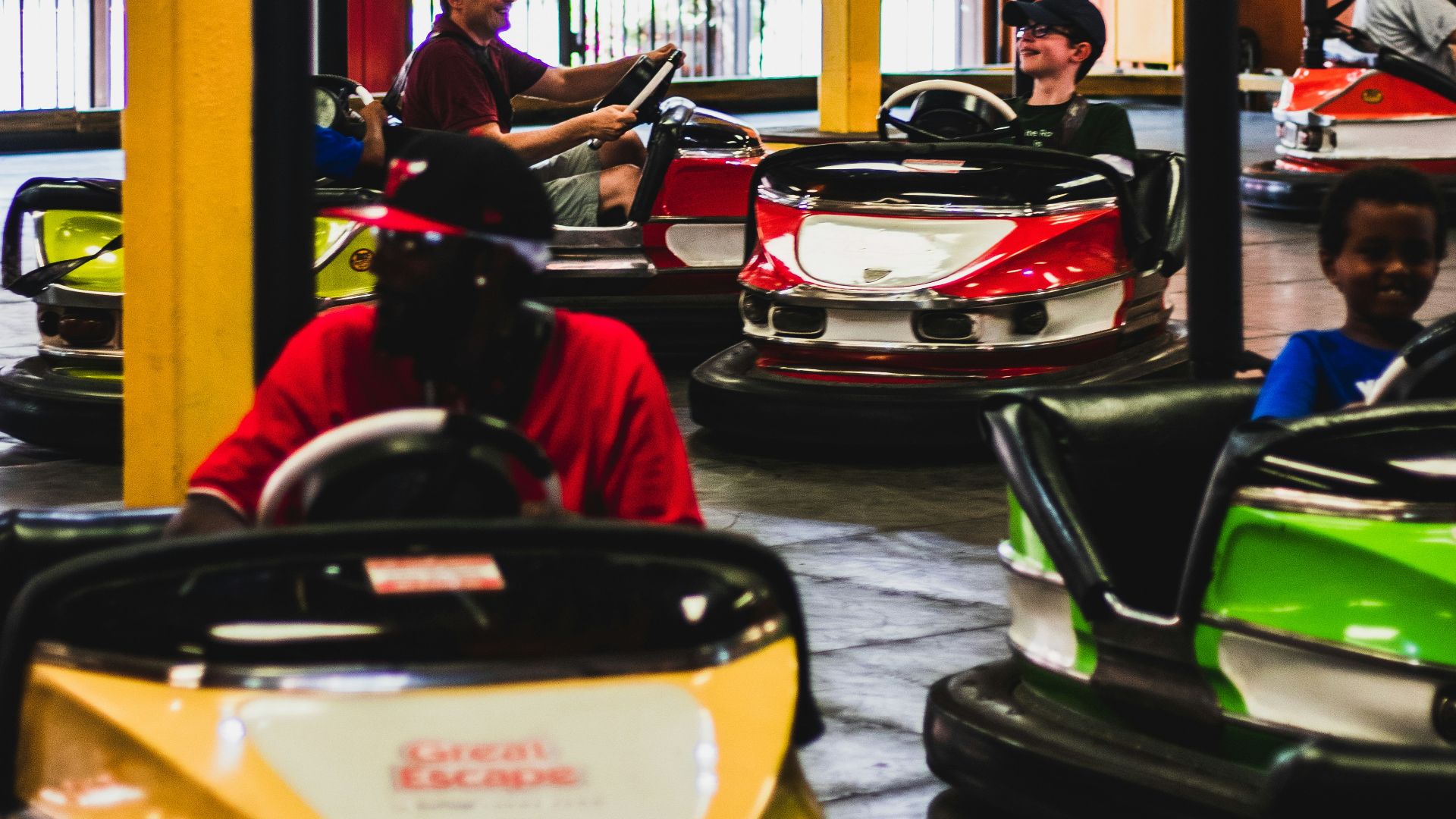 a group of people riding bumper cars inside of a building