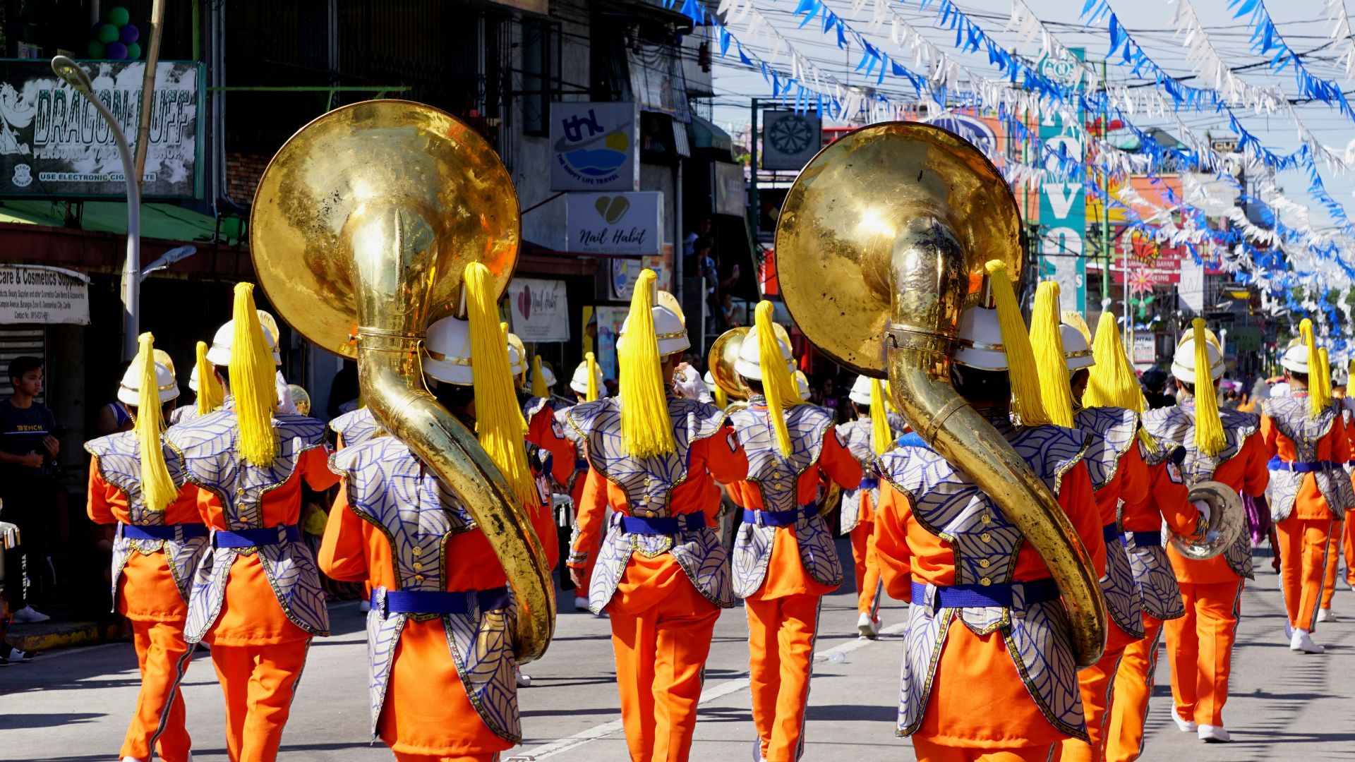 people in orange and blue costume walking on street during daytime