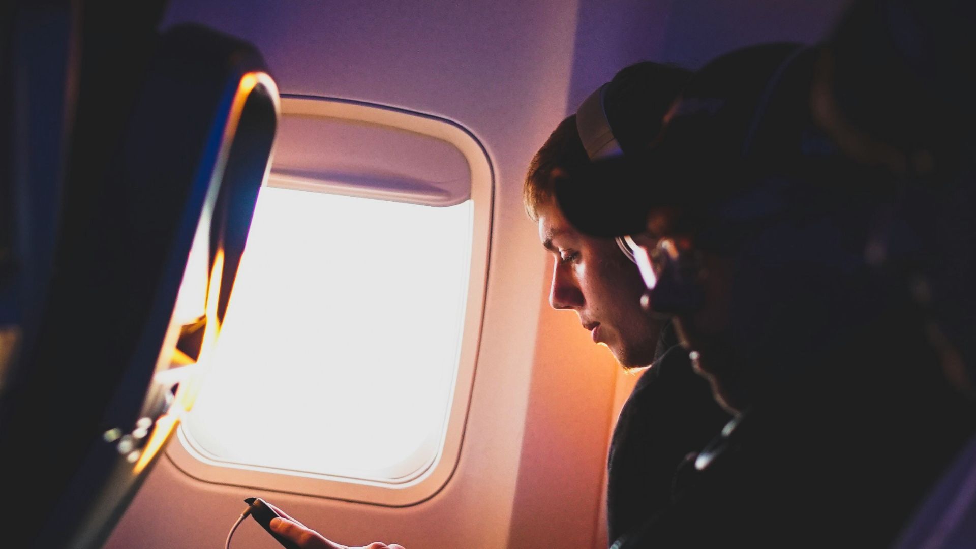 photo of three people listening to music inside airplane