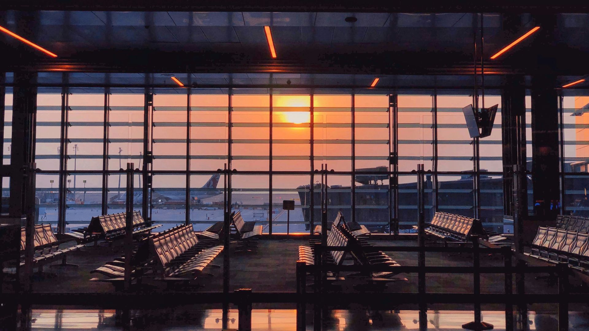 the sun is setting through the window of an airport