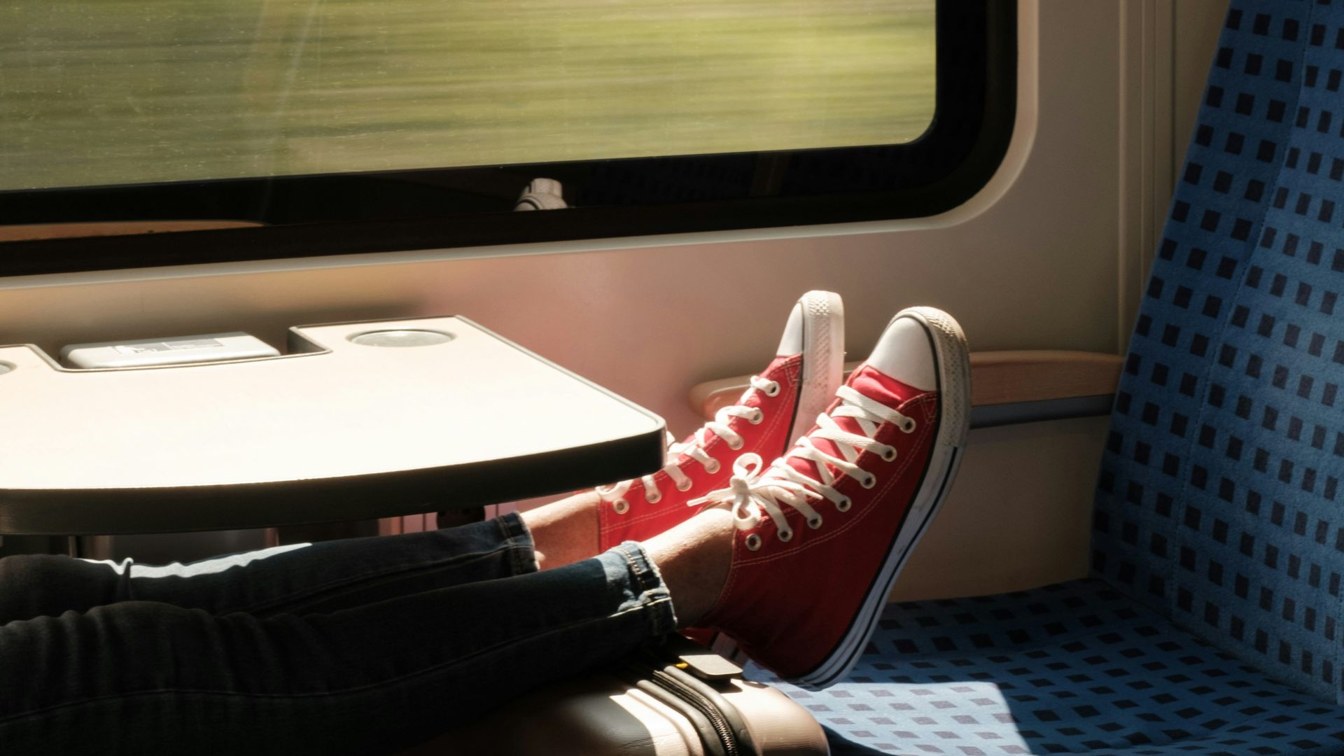 person in red and white sneakers sitting on blue and white chair