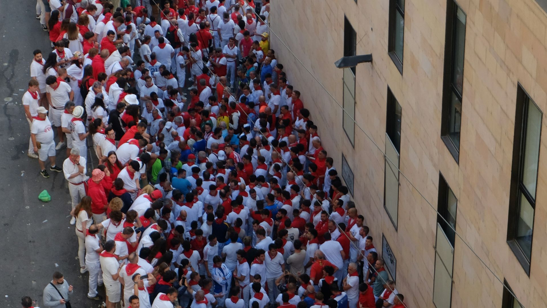 Crowd of people in white shirts and red sashes