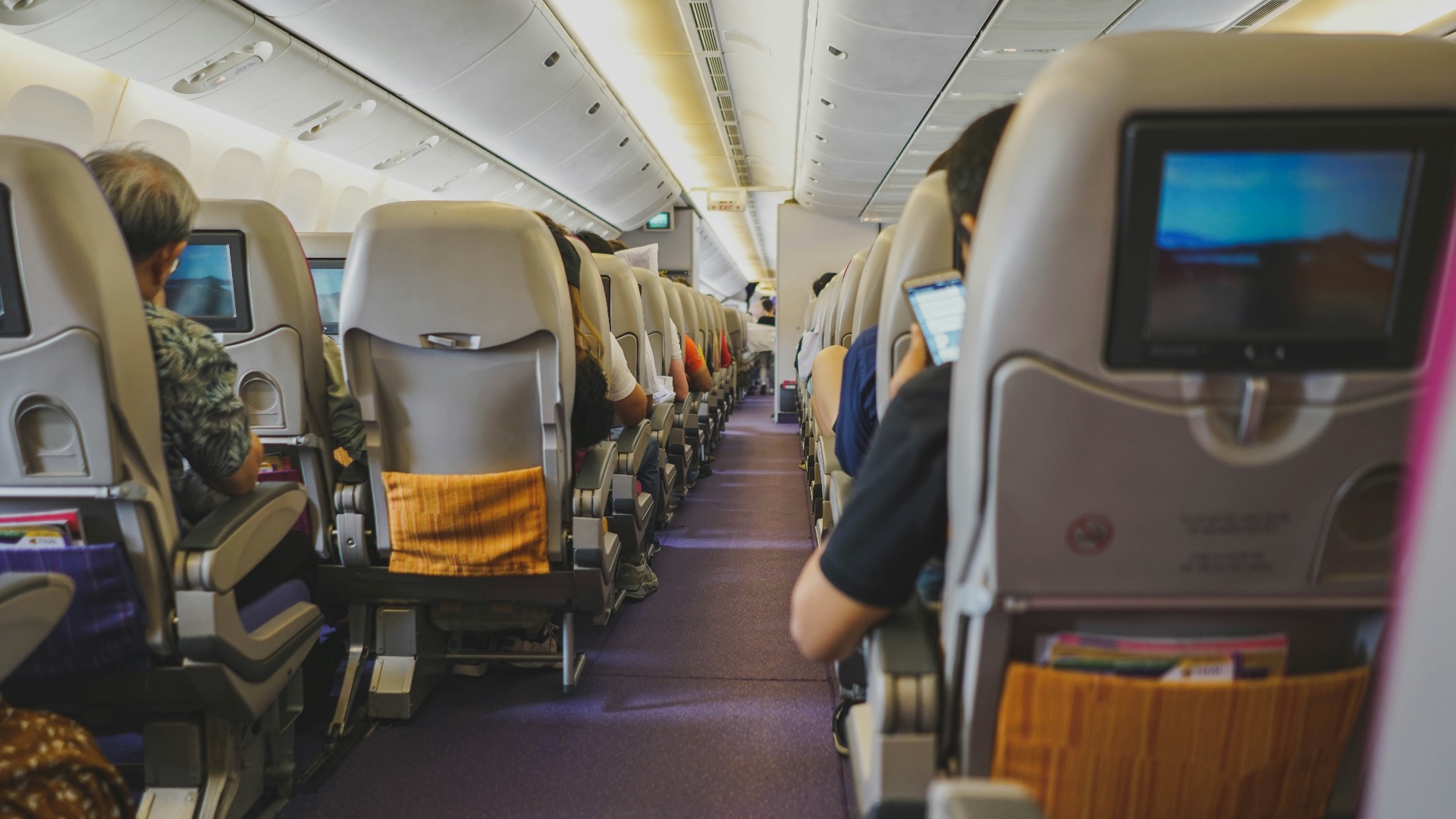 people sitting on chairs inside airplane