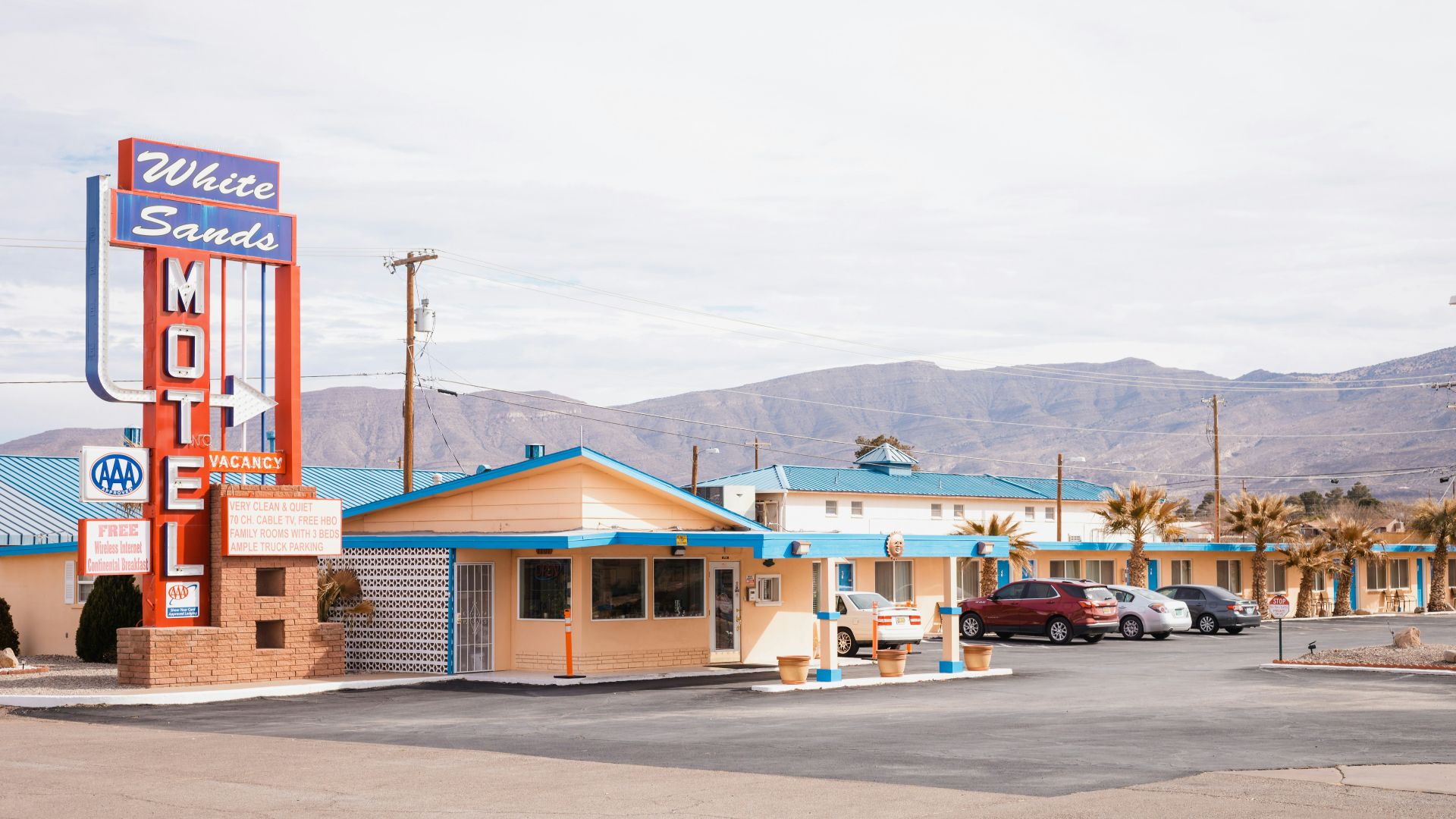 a motel with cars parked in front of it