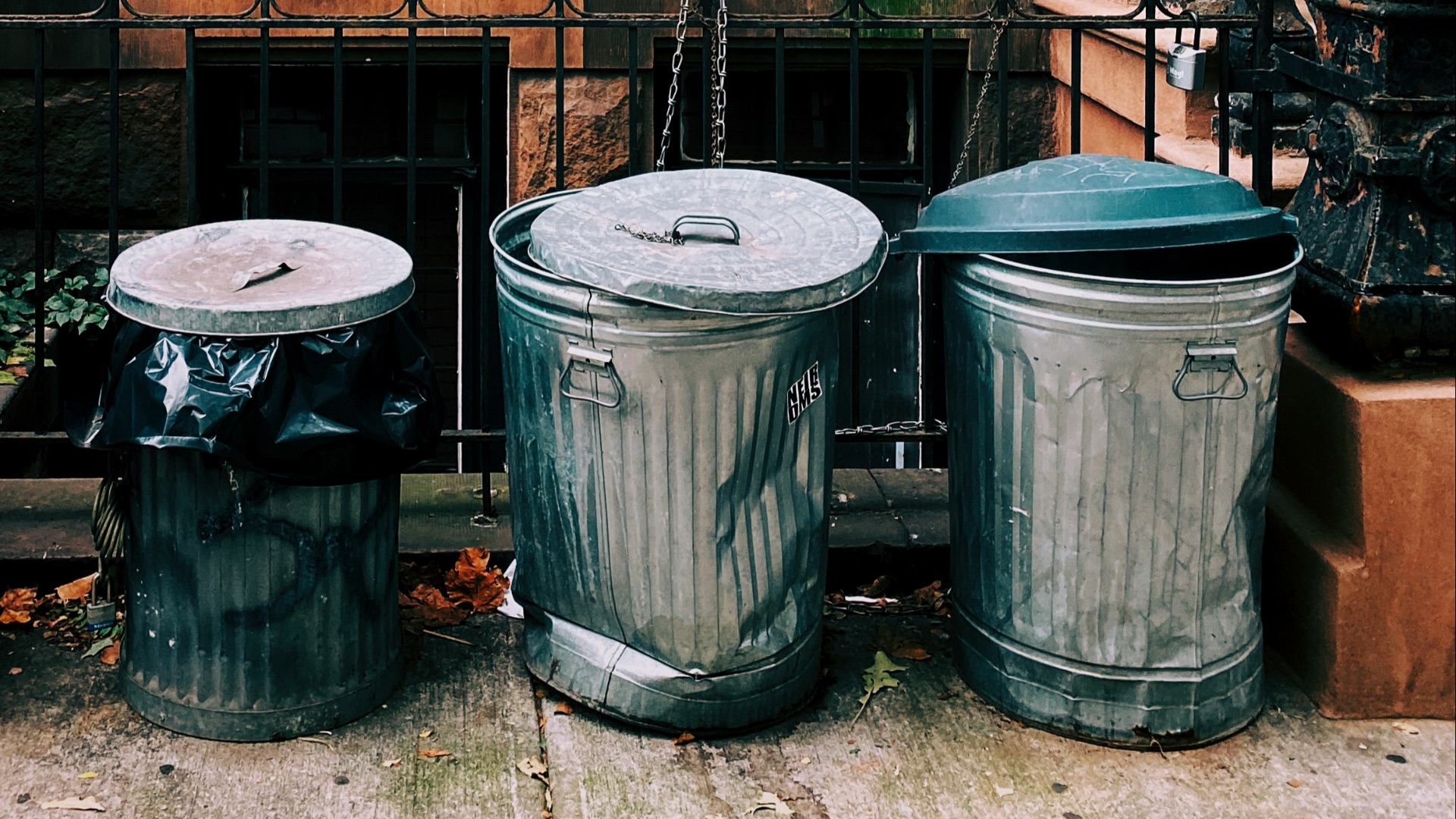 three gray stainless steel trash bins