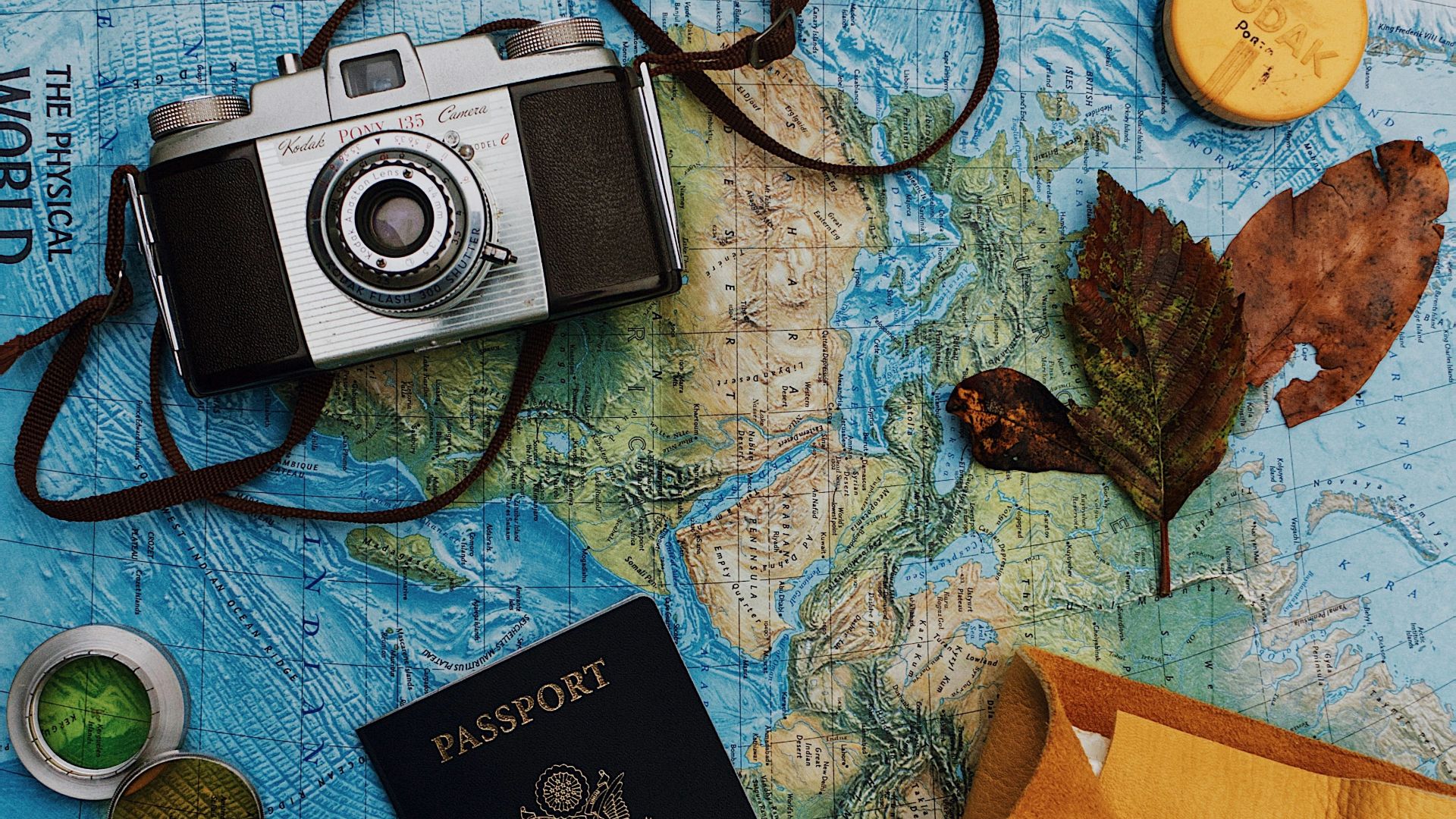 flatlay photography of camera, laptop, and passport