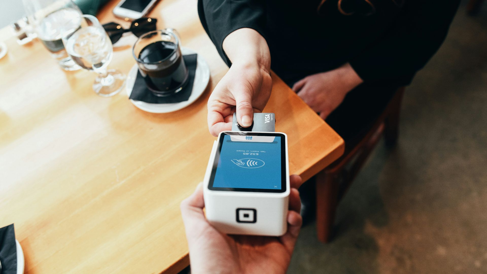 person holding credit card swipe machine