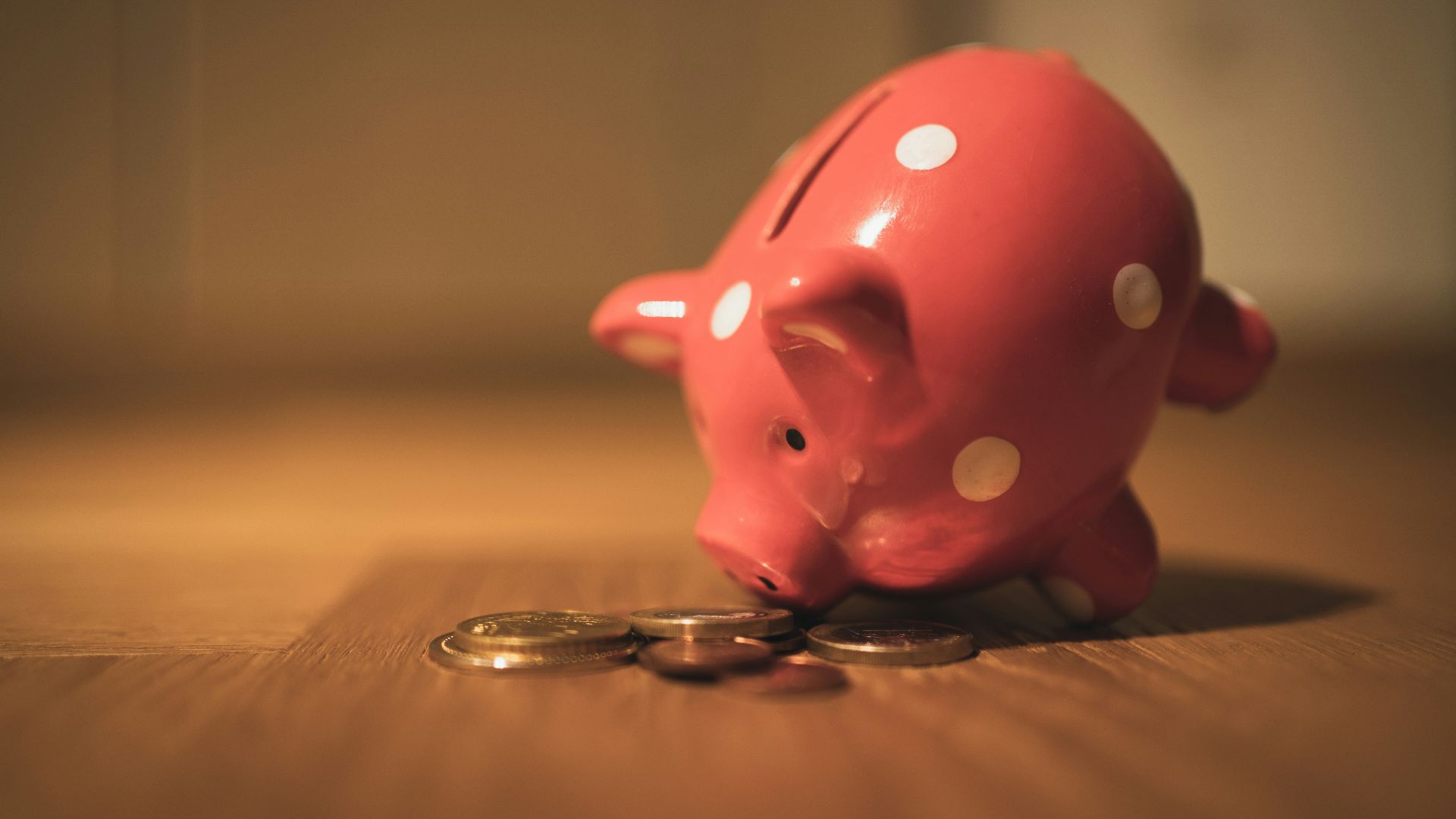 pink pig coin bank on brown wooden table