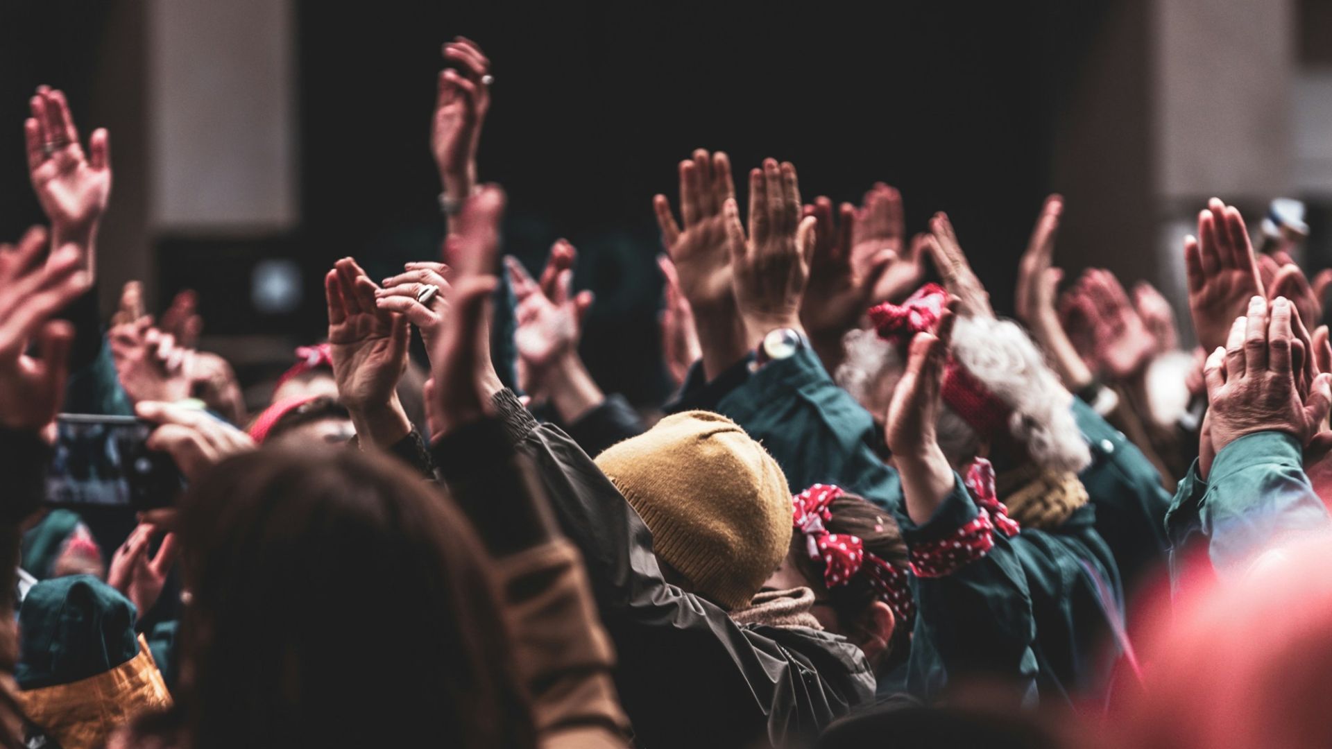 a large group of people with their hands in the air