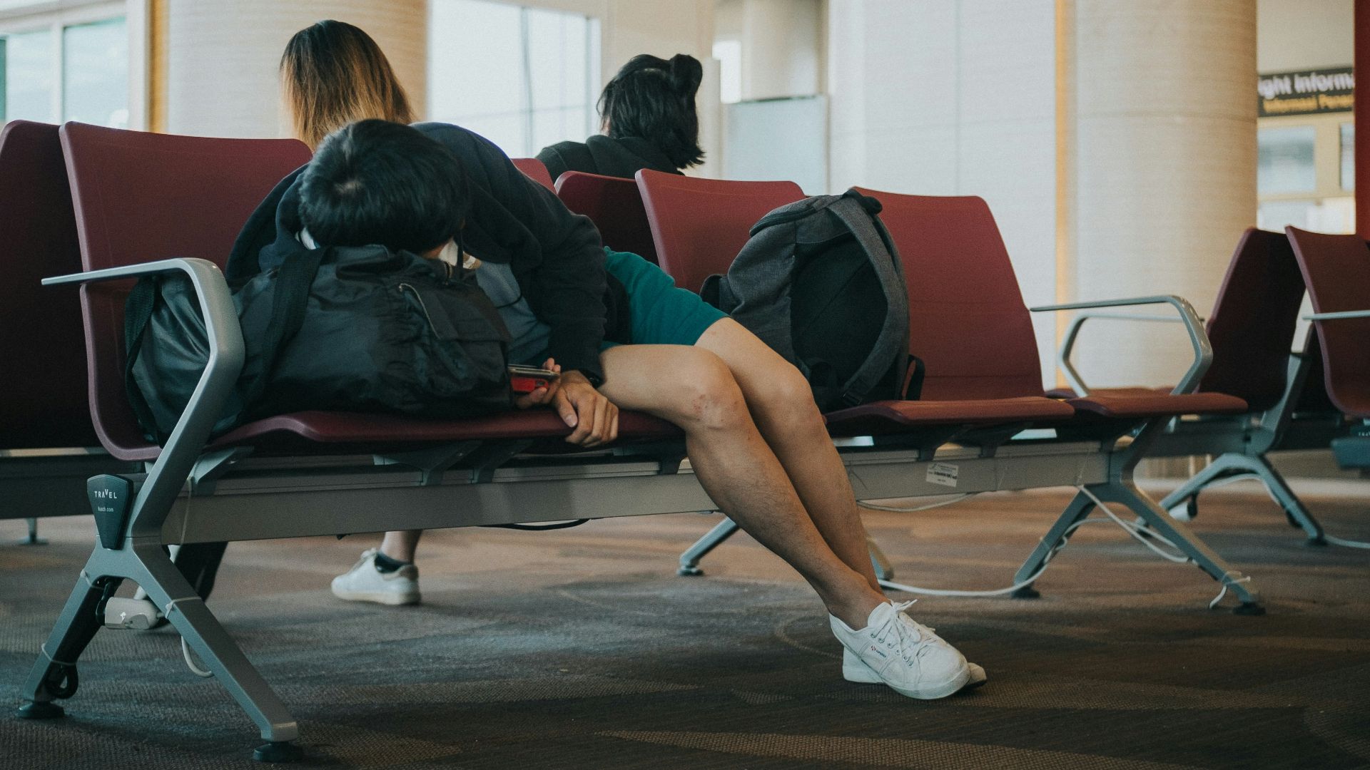 unknown person lying on brown bench indoors