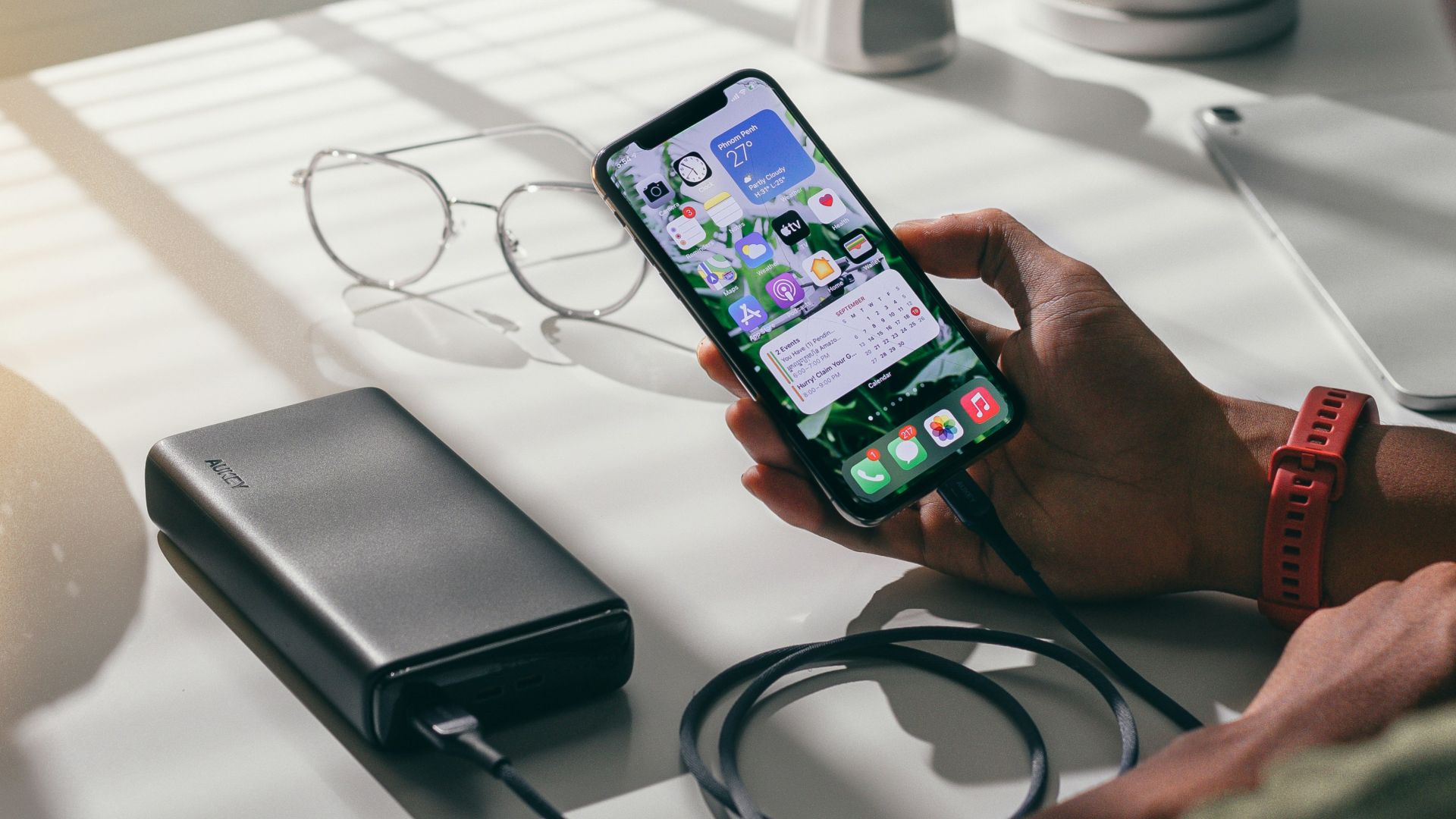 person holding black smartphone on white textile