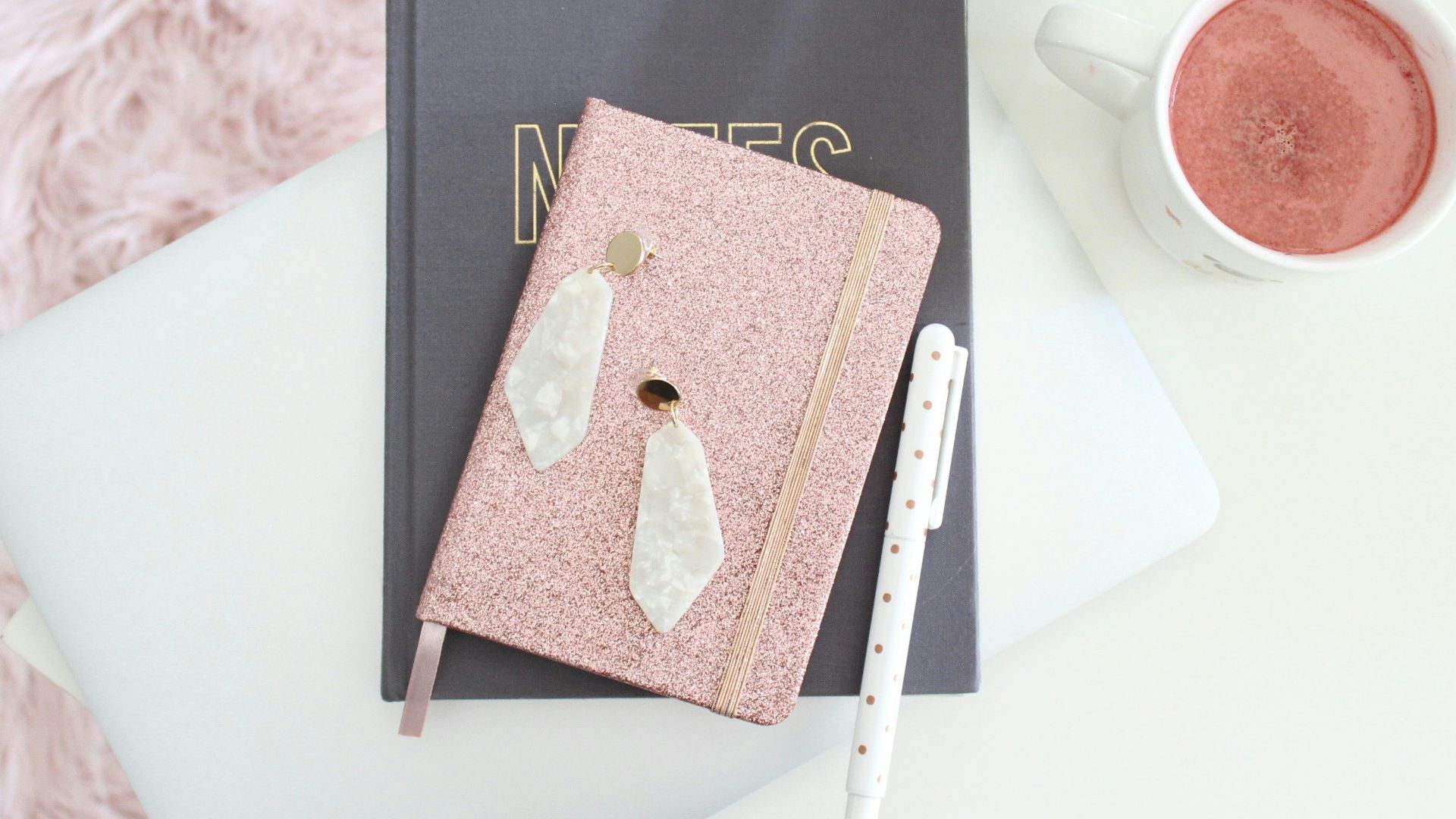 brown book on black book beside white ceramic mug