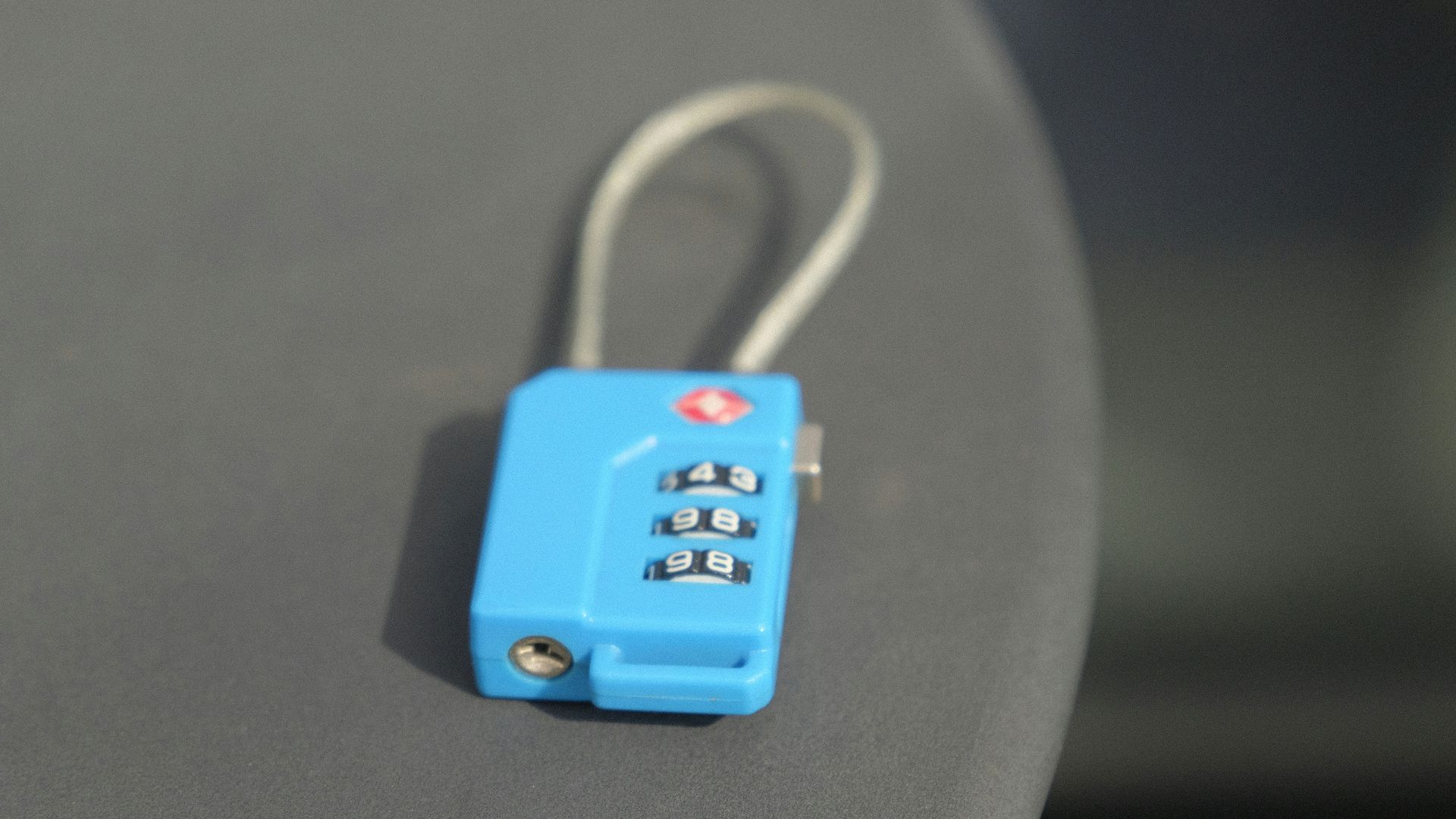 A small blue combination lock rests on a surface.