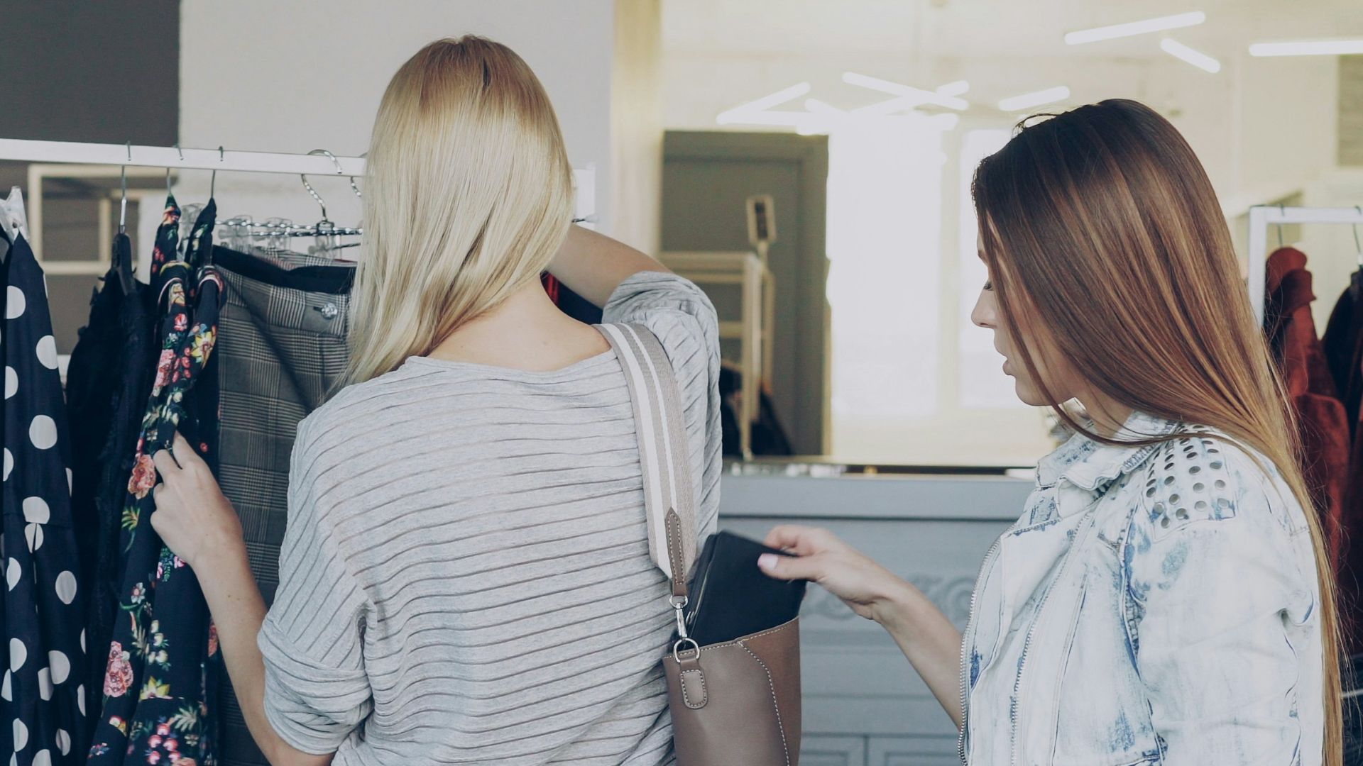 Two women shop for clothes in a store.