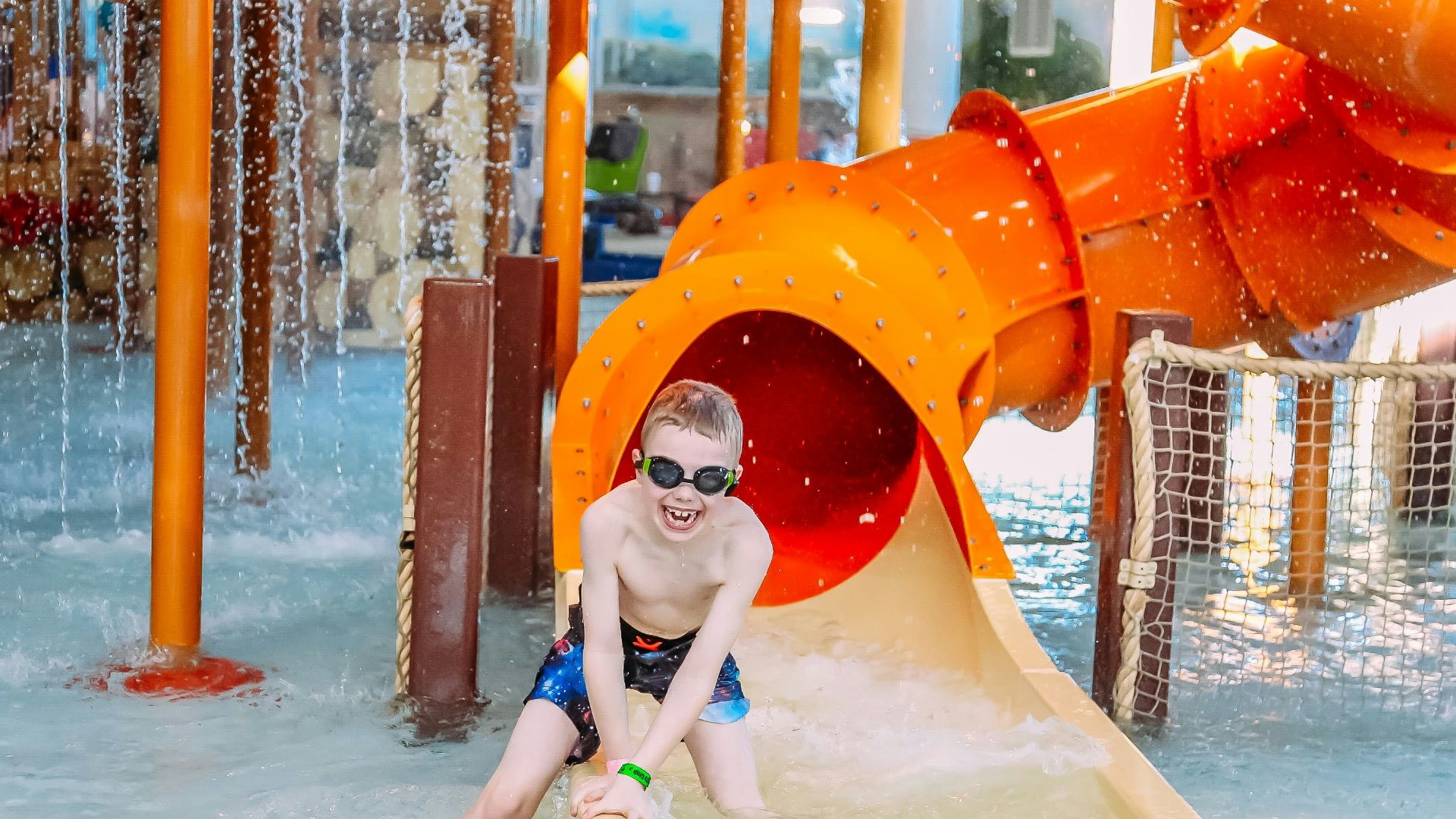 a young boy on a water slide at a water park