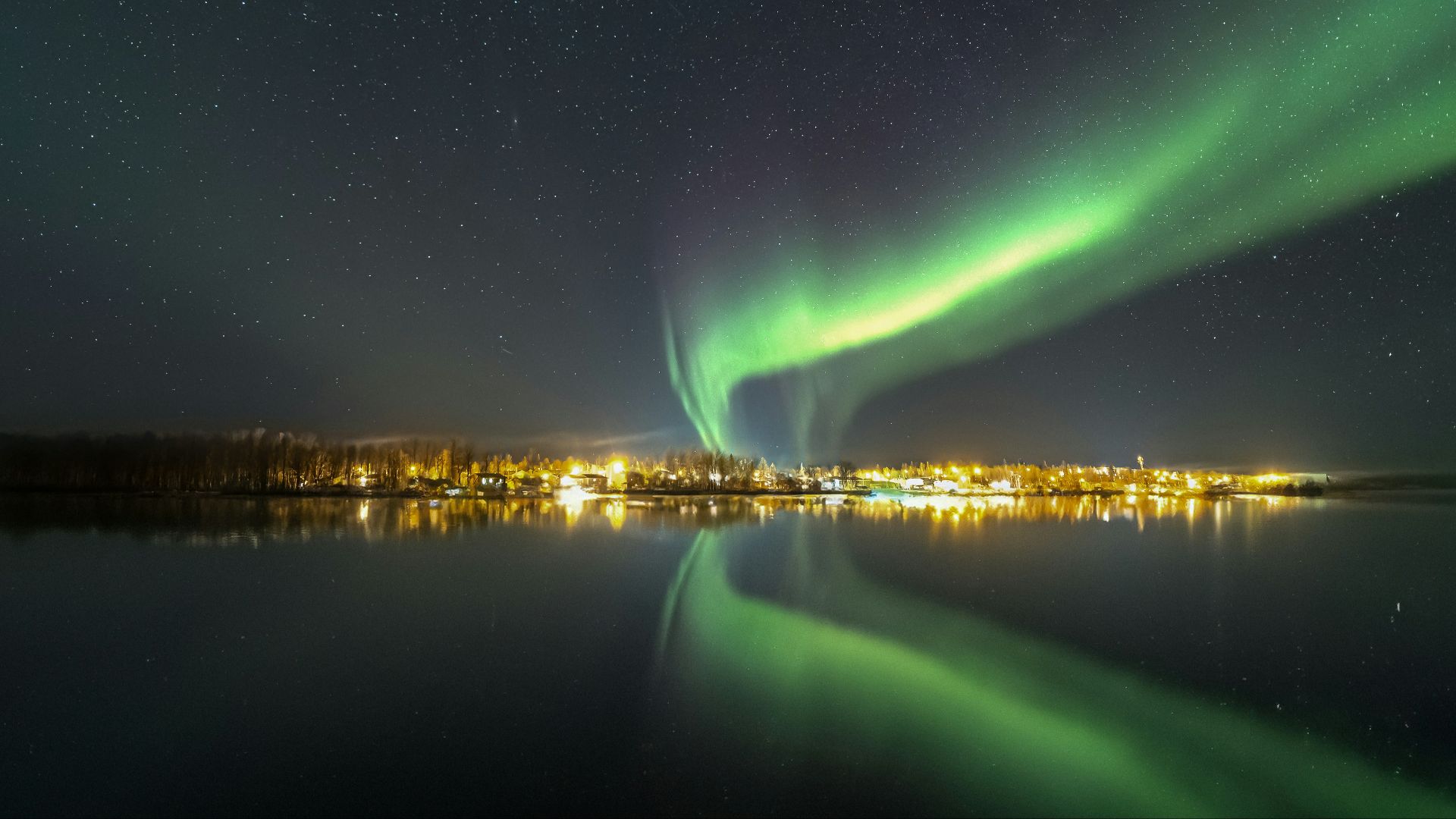 the aurora bore is reflected in the water at night
