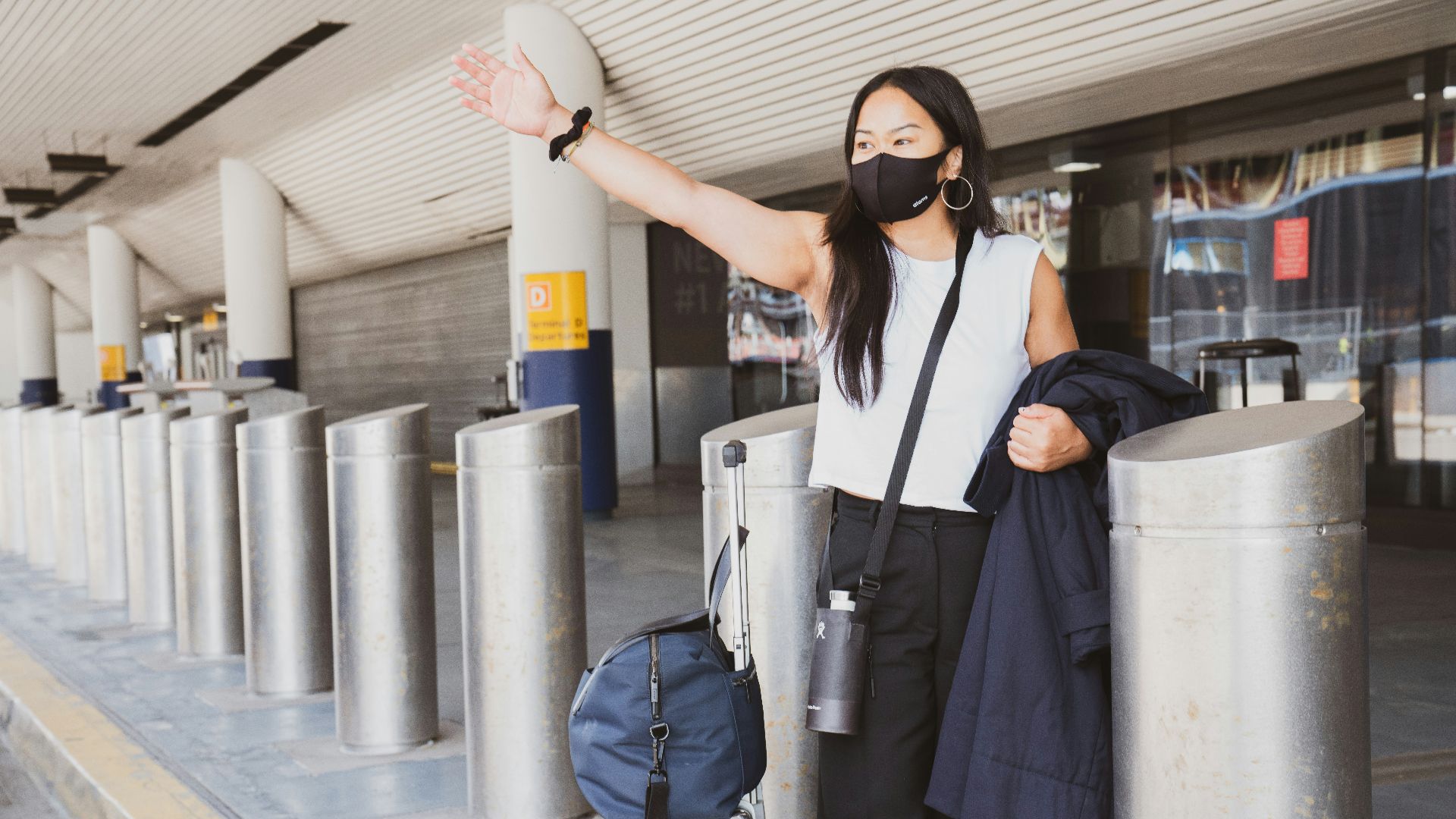 woman in black dress wearing black sunglasses holding white and black walking stick