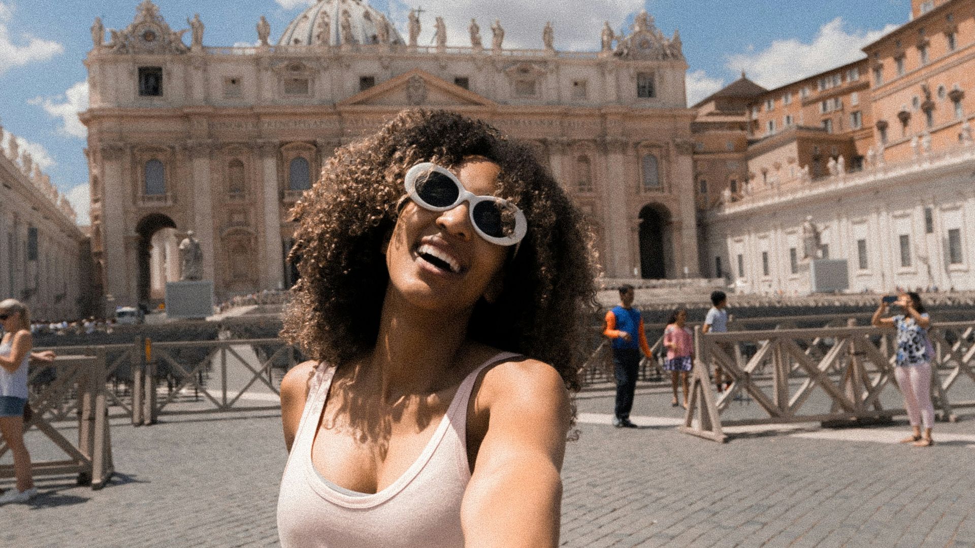 woman holding person's hand near buildings under white and blue cloudy sky
