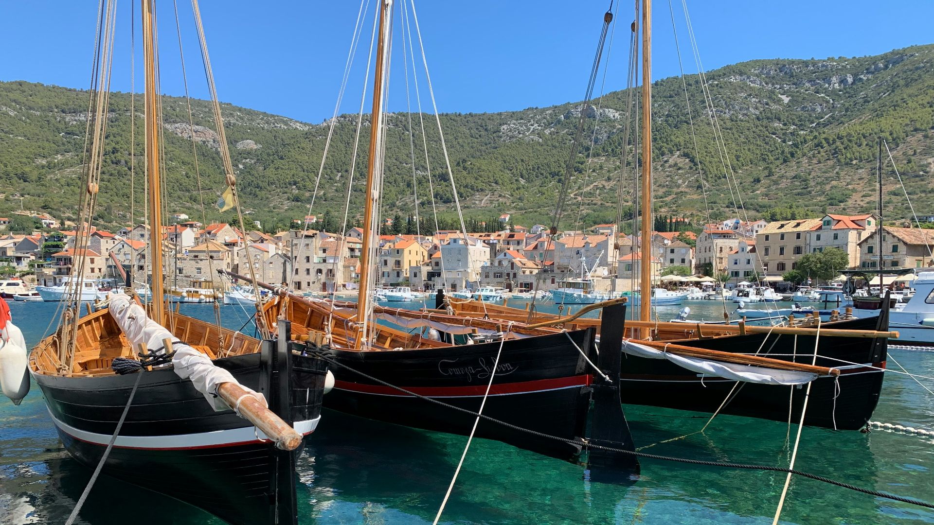 brown and white sail boat on blue water during daytime