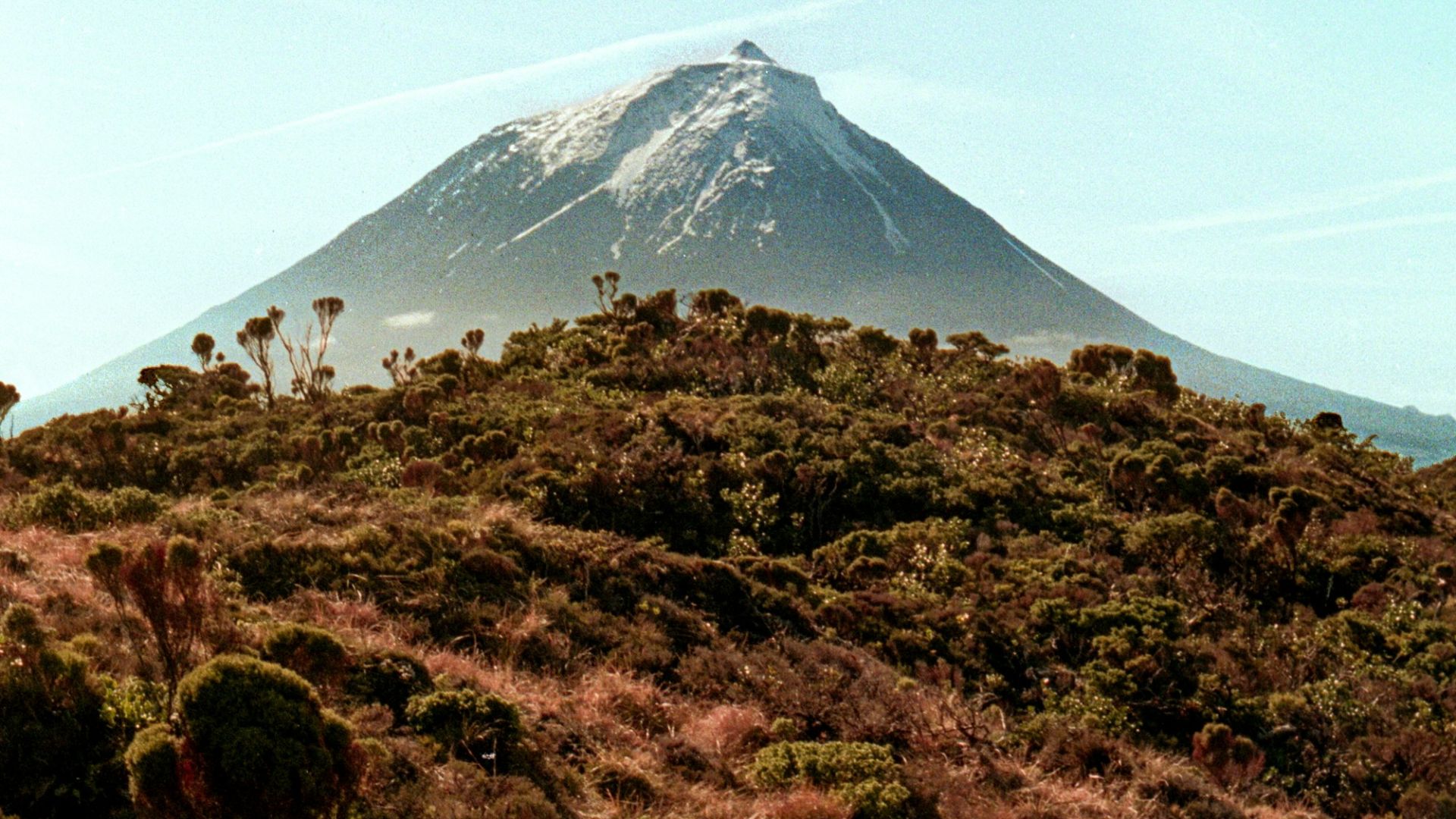 A mountain looms over a hillside.