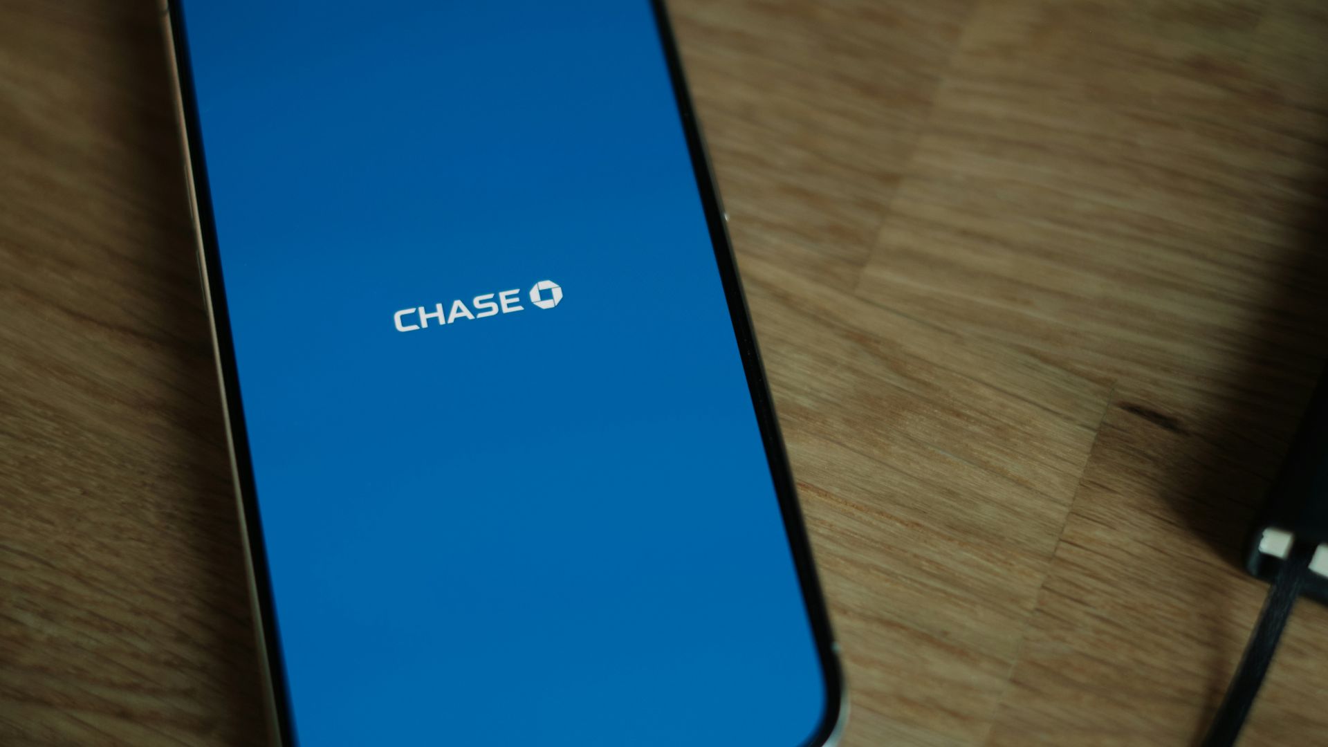 A cell phone sitting on top of a wooden table