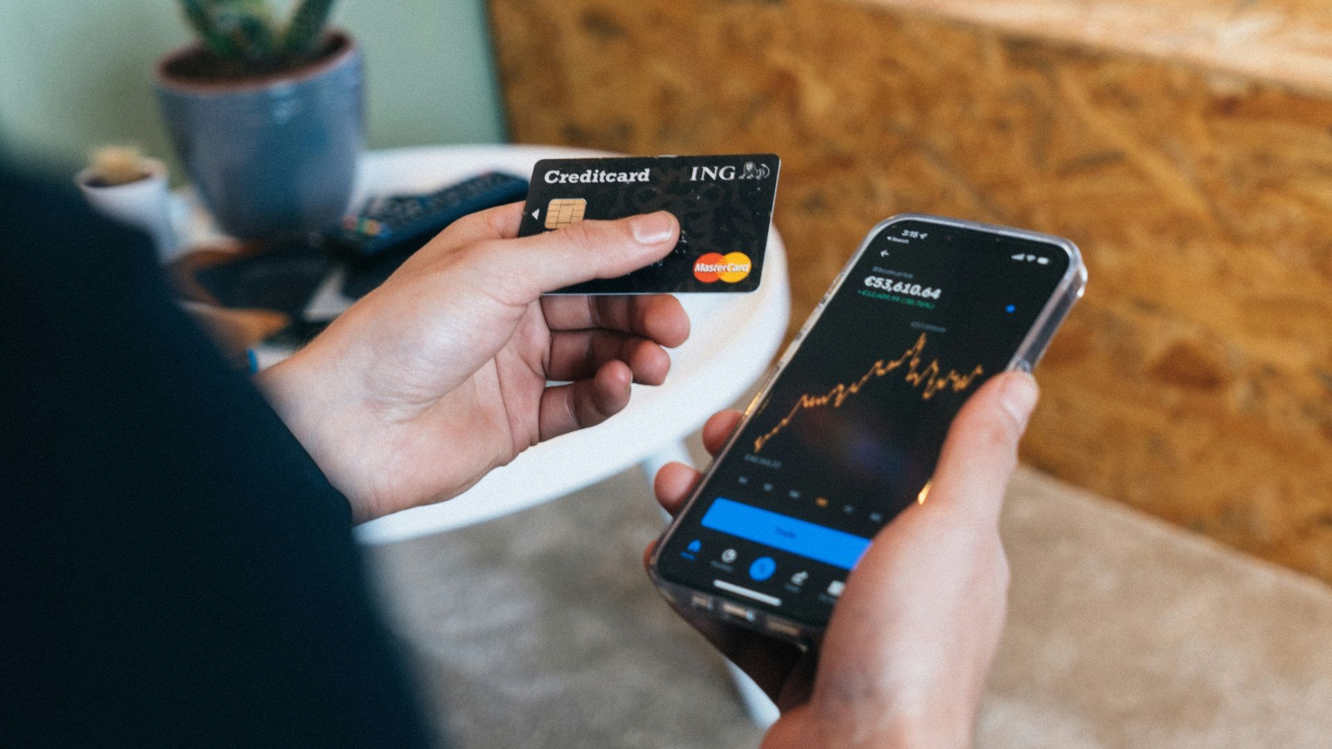 a person holding a smart phone and a credit card
