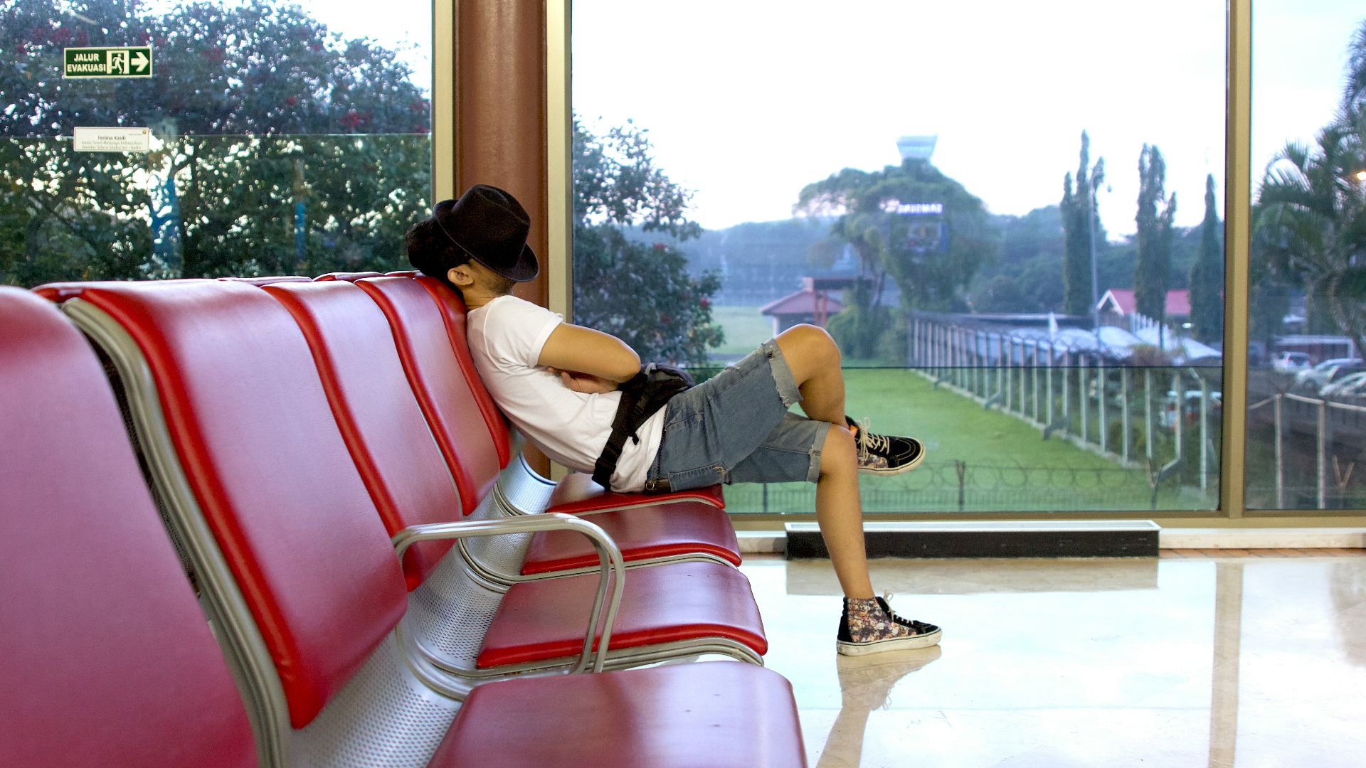 unknown person sitting on red gang chair indoors