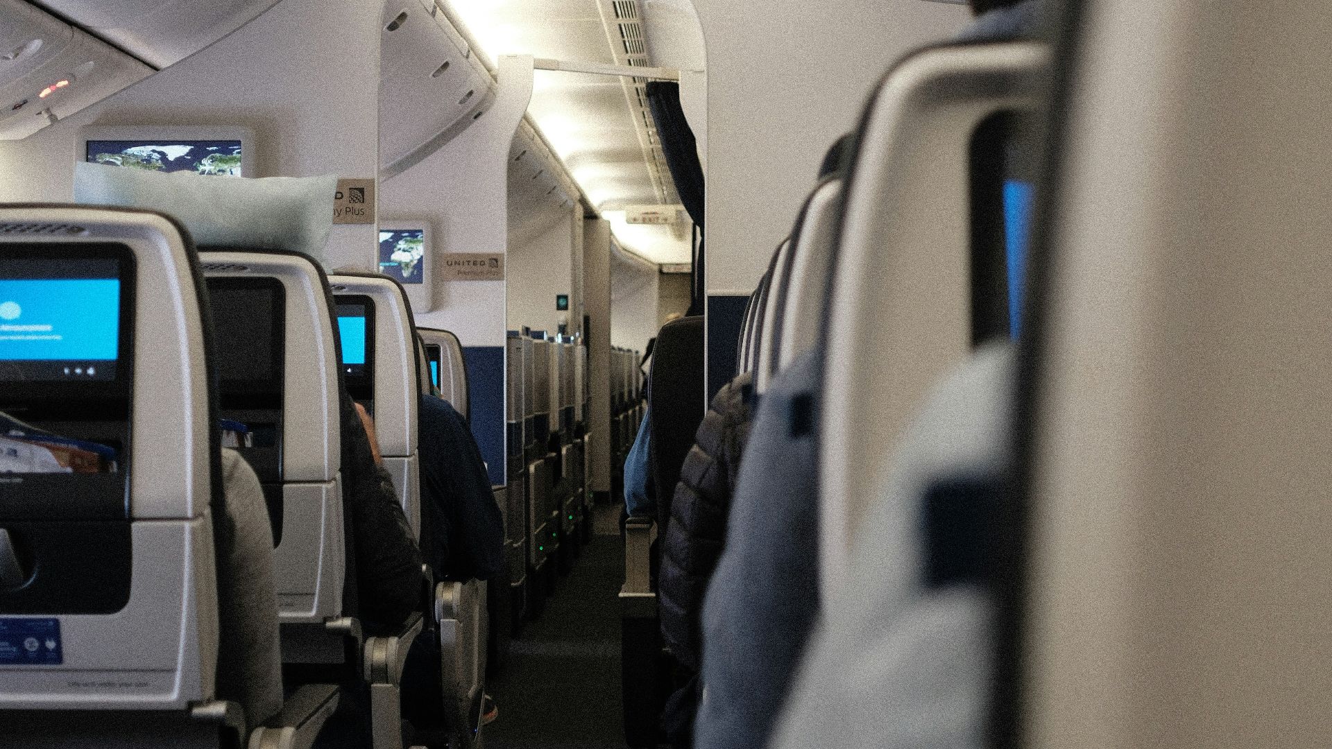 a row of seats on an airplane with people sitting on them