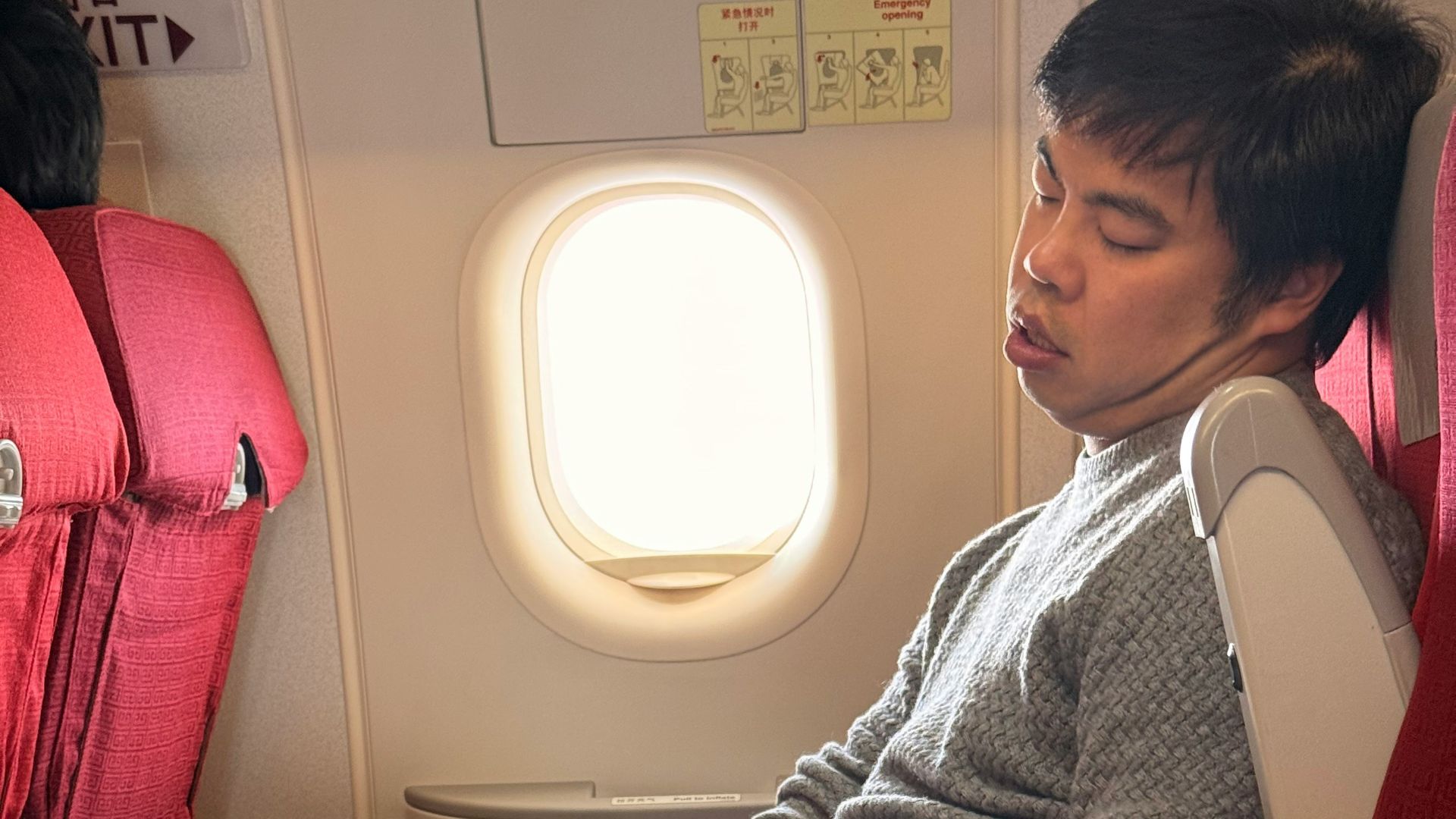 Man sleeping on airplane with laptop on tray