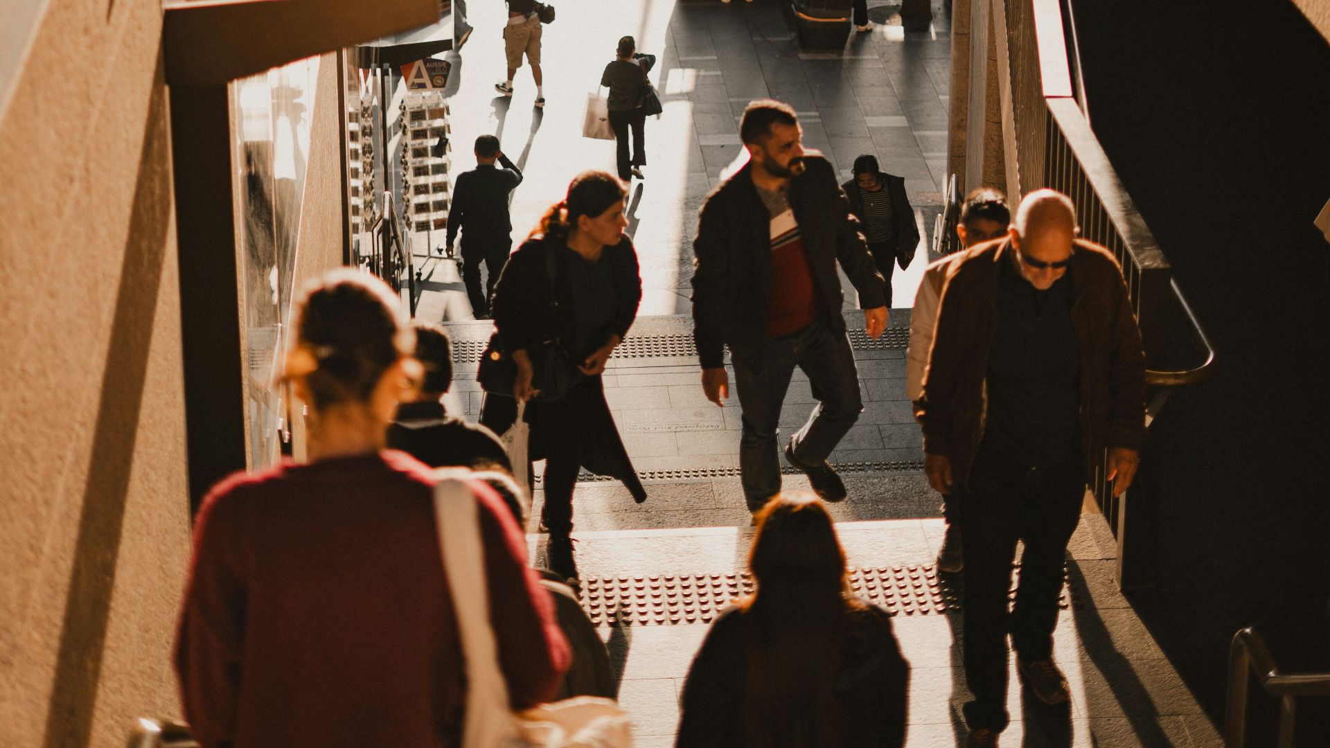 People walking down stairs towards a busy street.