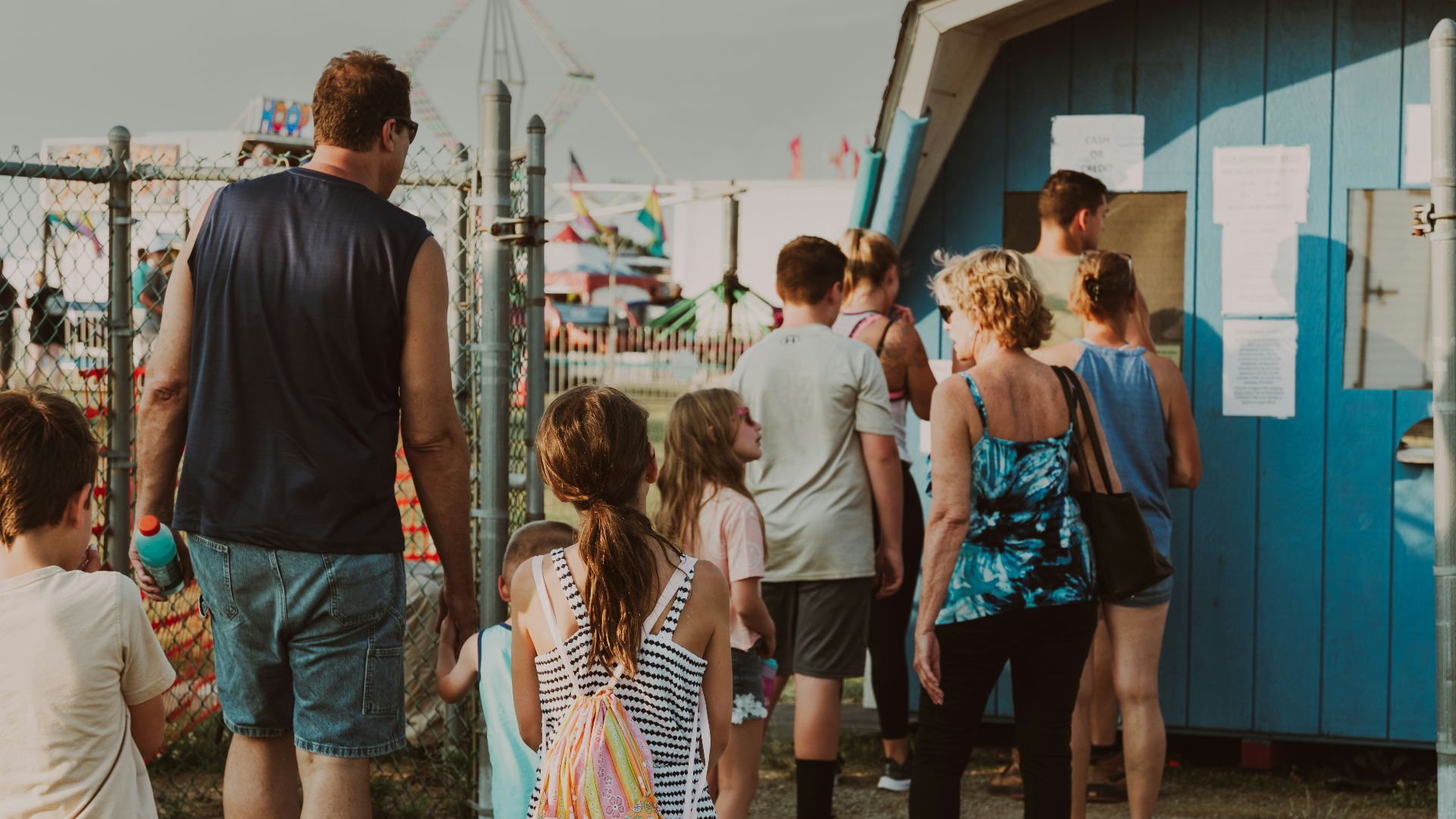 A group of people standing around a blue shack