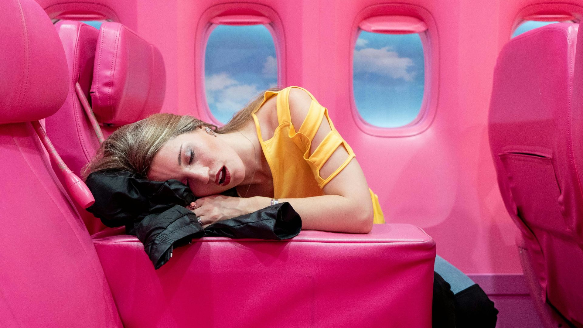 girl in yellow long sleeve shirt lying on red inflatable bed