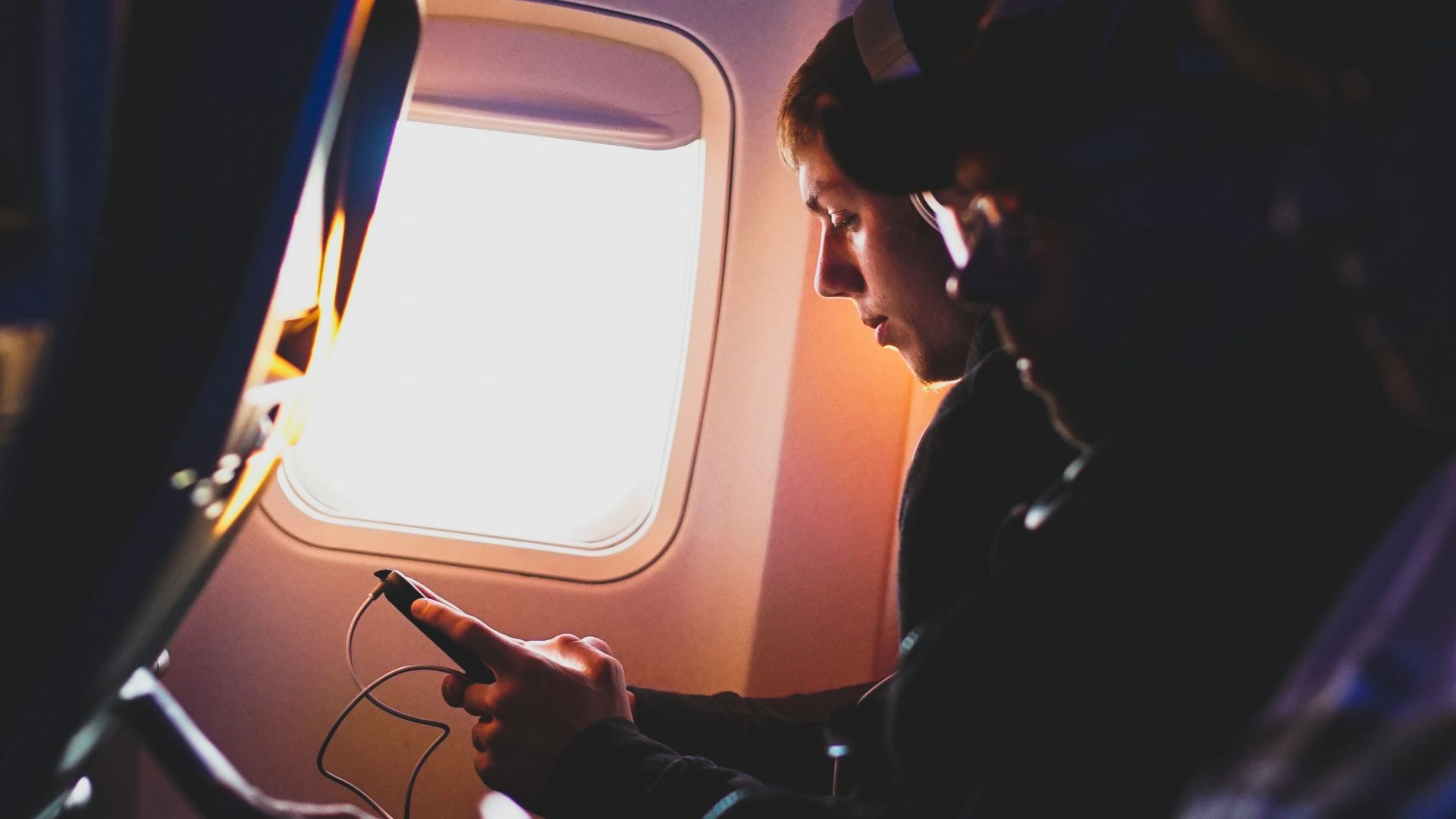 photo of three people listening to music inside airplane